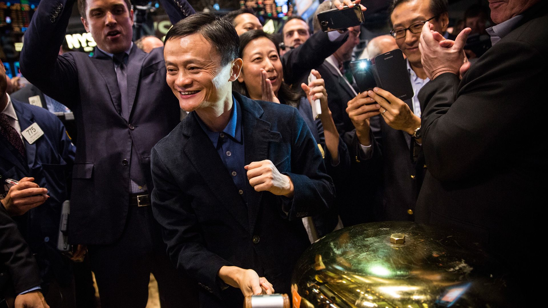 Jack Ma rings a bell, surrounded by cheering people