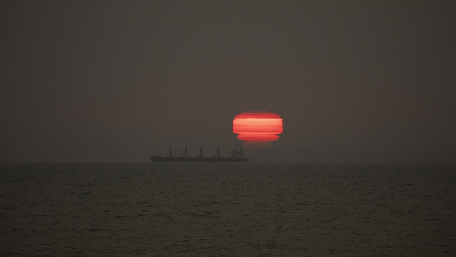 The sun rises through the smoke from Australia's Bushfires drifts over New Zealand, at New Brighton Beach in Christchurch, New Zealand on January 01,