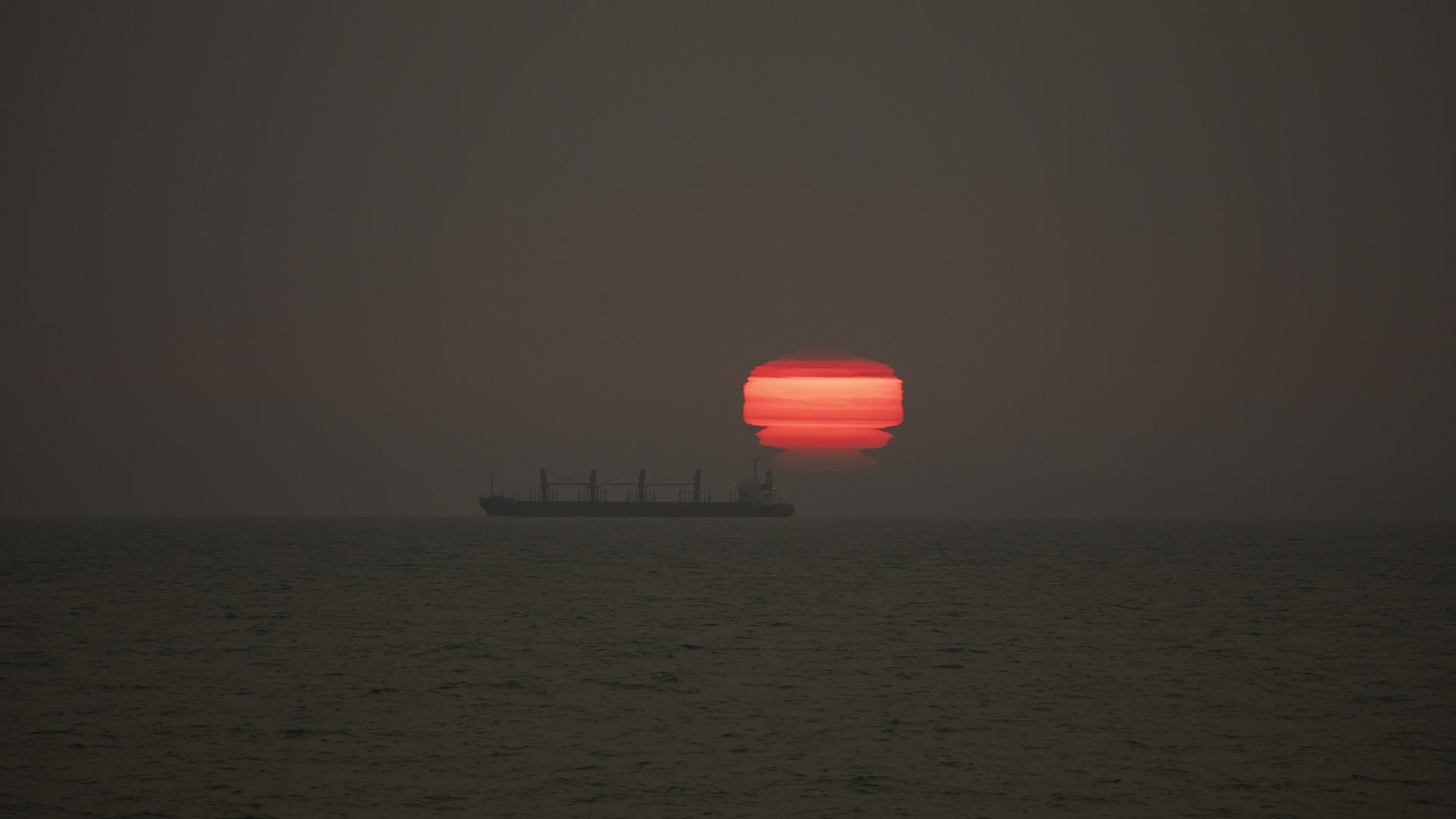 The sun rises through the smoke from Australia's Bushfires drifts over New Zealand, at New Brighton Beach in Christchurch, New Zealand on January 01,