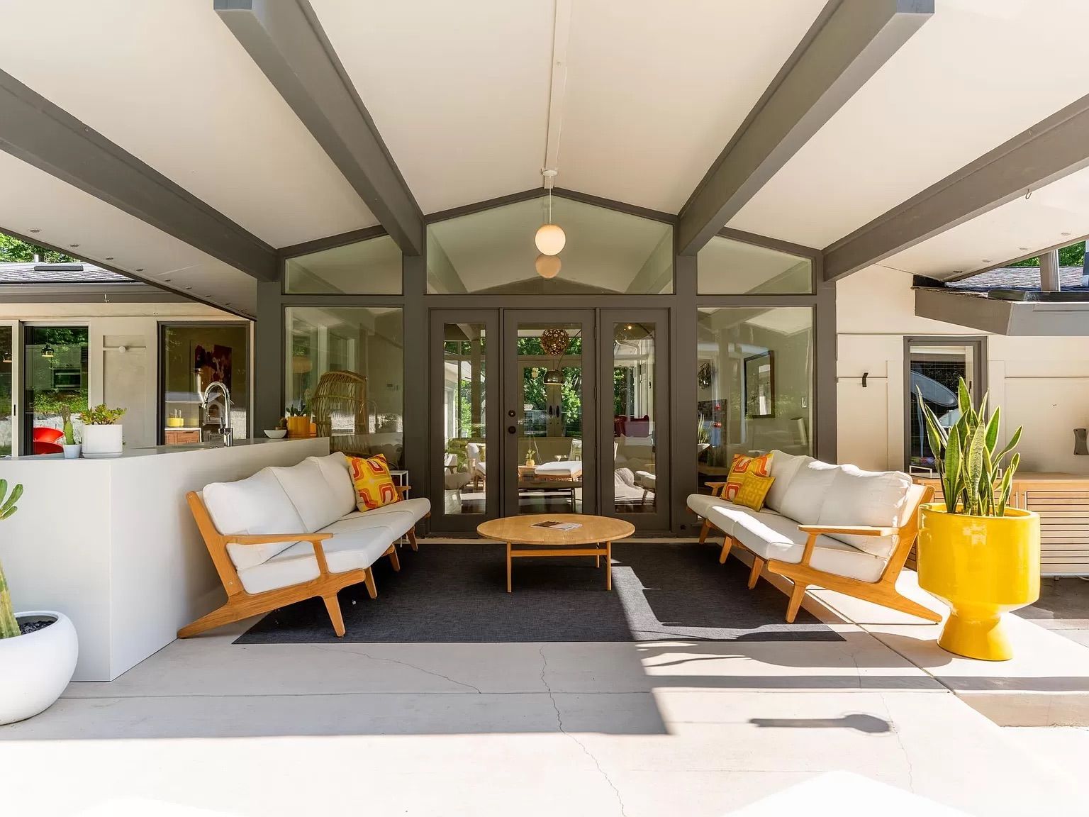 A covered patio with a patio couch and table.