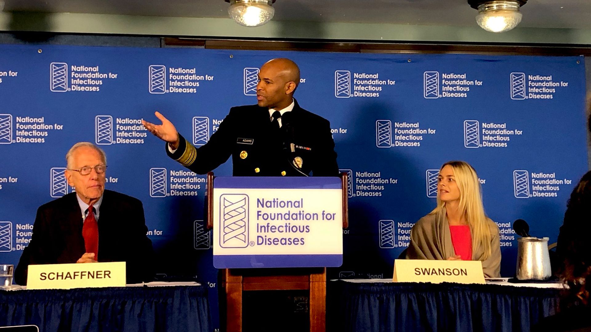 Photo of U.S. Surgeon General Jerome Adams speaking at podium about flu vaccine
