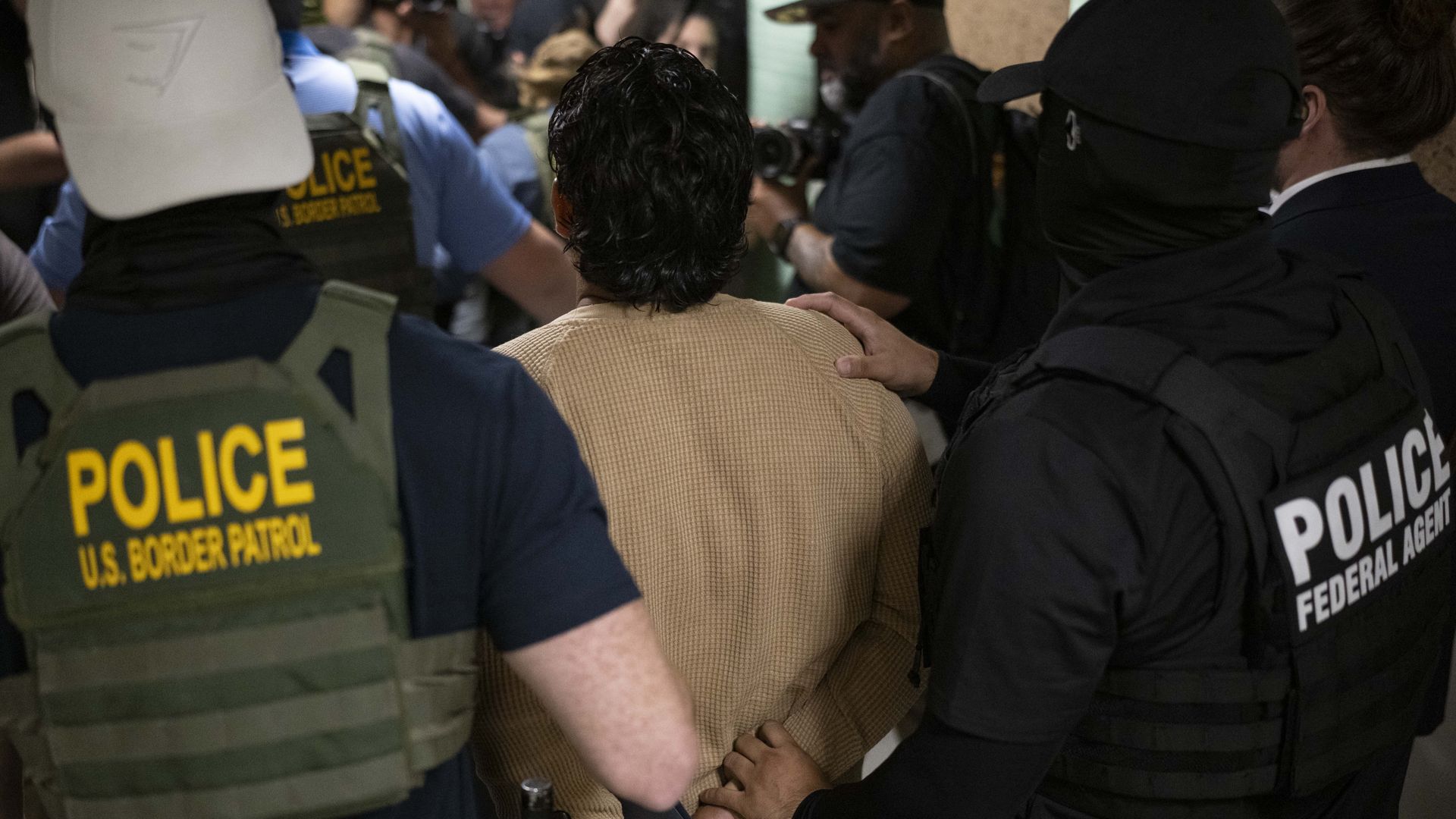 Federal agents detain a person after attending a court hearing at immigration court in New York City.