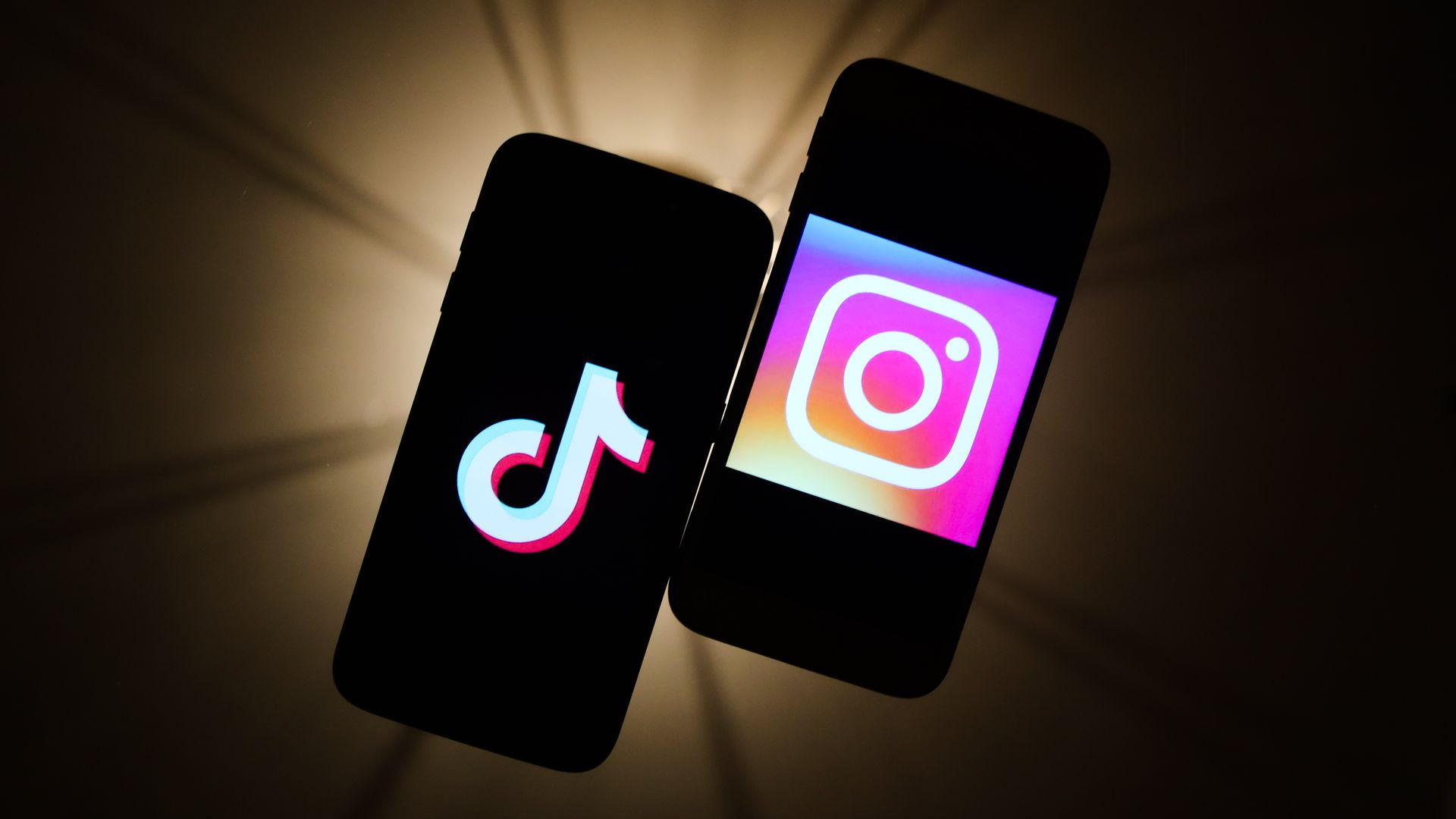 TikTok and Instagram logos are seen displayed on a phone screens in this illustration photo.