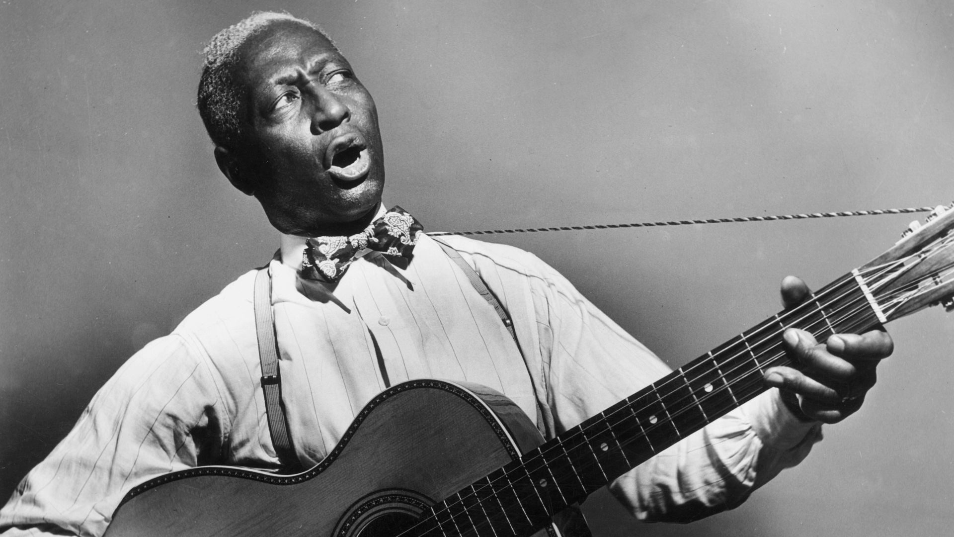 A black-and-white portrait from around 1935 of American blues musician Huddie "Lead Belly" Ledbetter