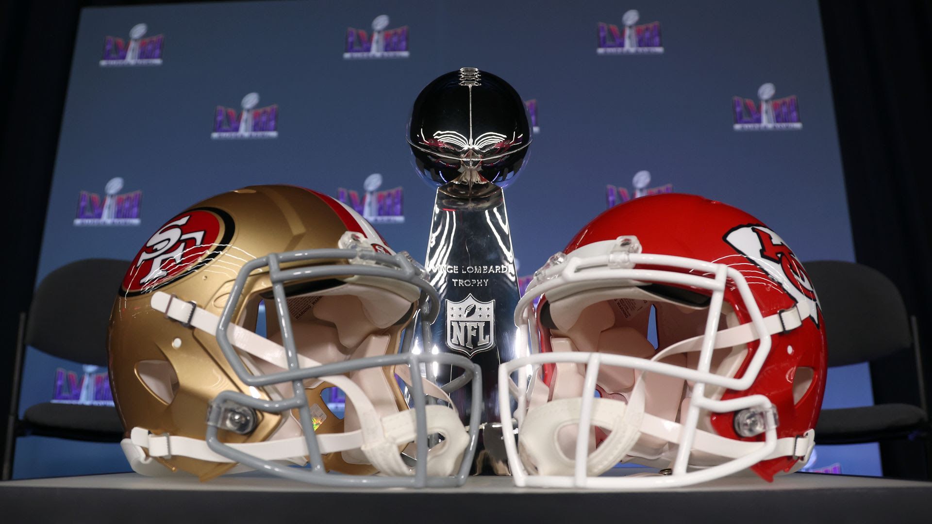 The helmets of the San Francisco 49ers and the Kansas City Chiefs in front of the Lombardi Trophy.