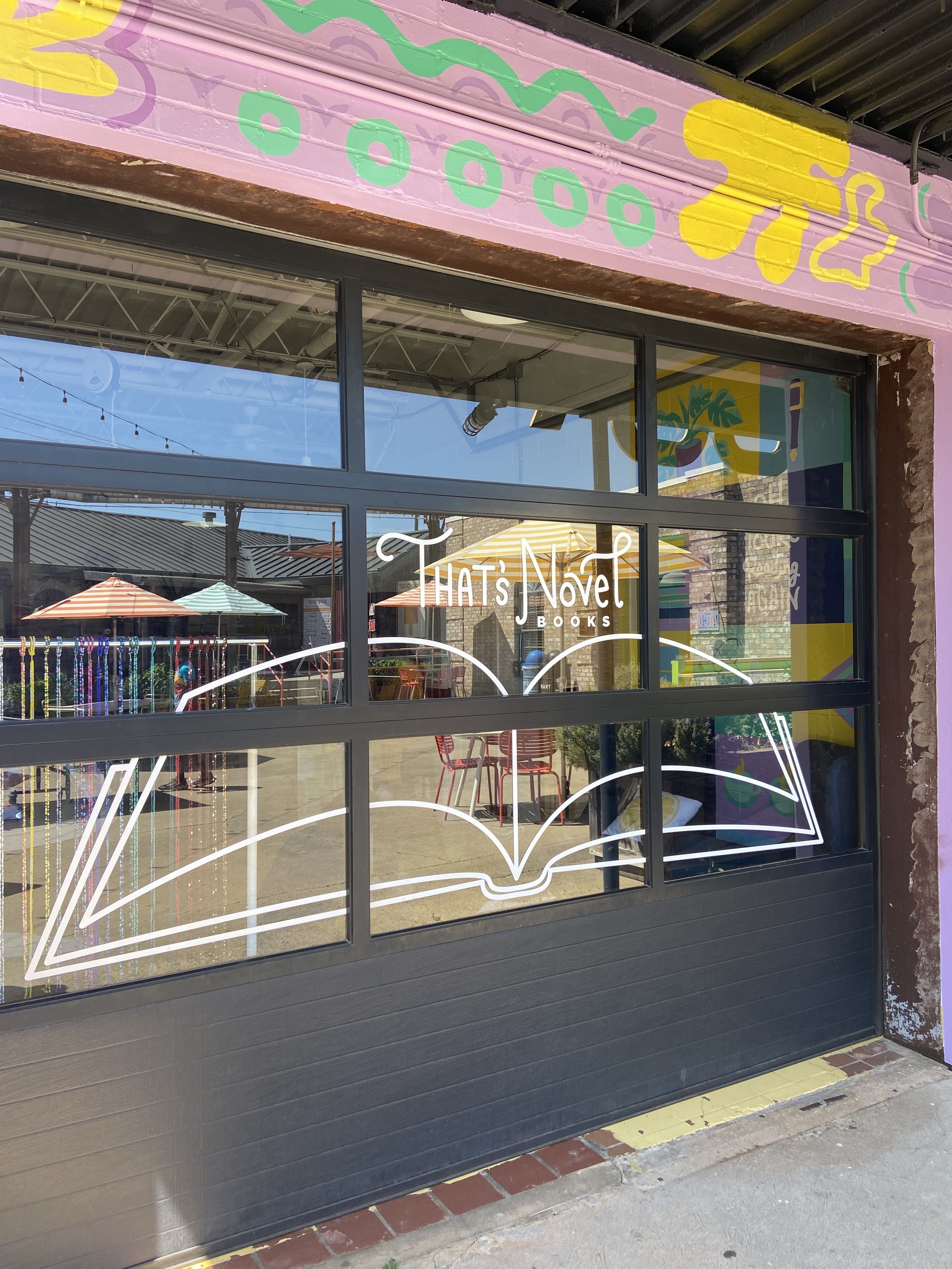 "That's Novel Books" above an etching of a book that spans a window in Camp North End.