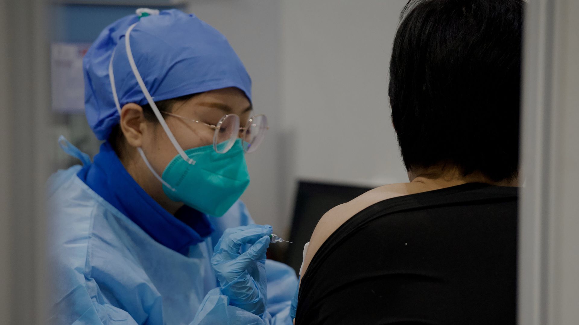 Picture of a medical worker inoculating a man with a Covid-19 vaccine in China