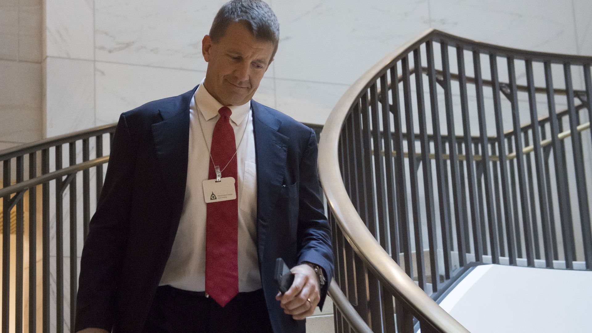 Erik Prince walks down stairs in Capitol Hill.