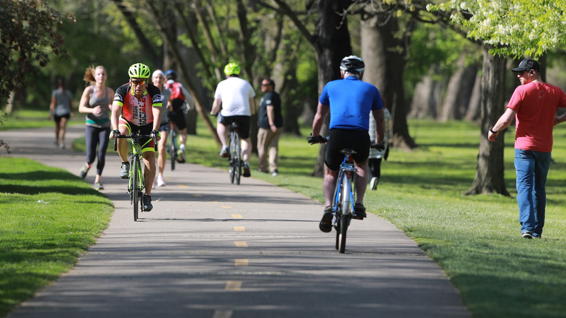 Parkgoers running and bicycling on a path.