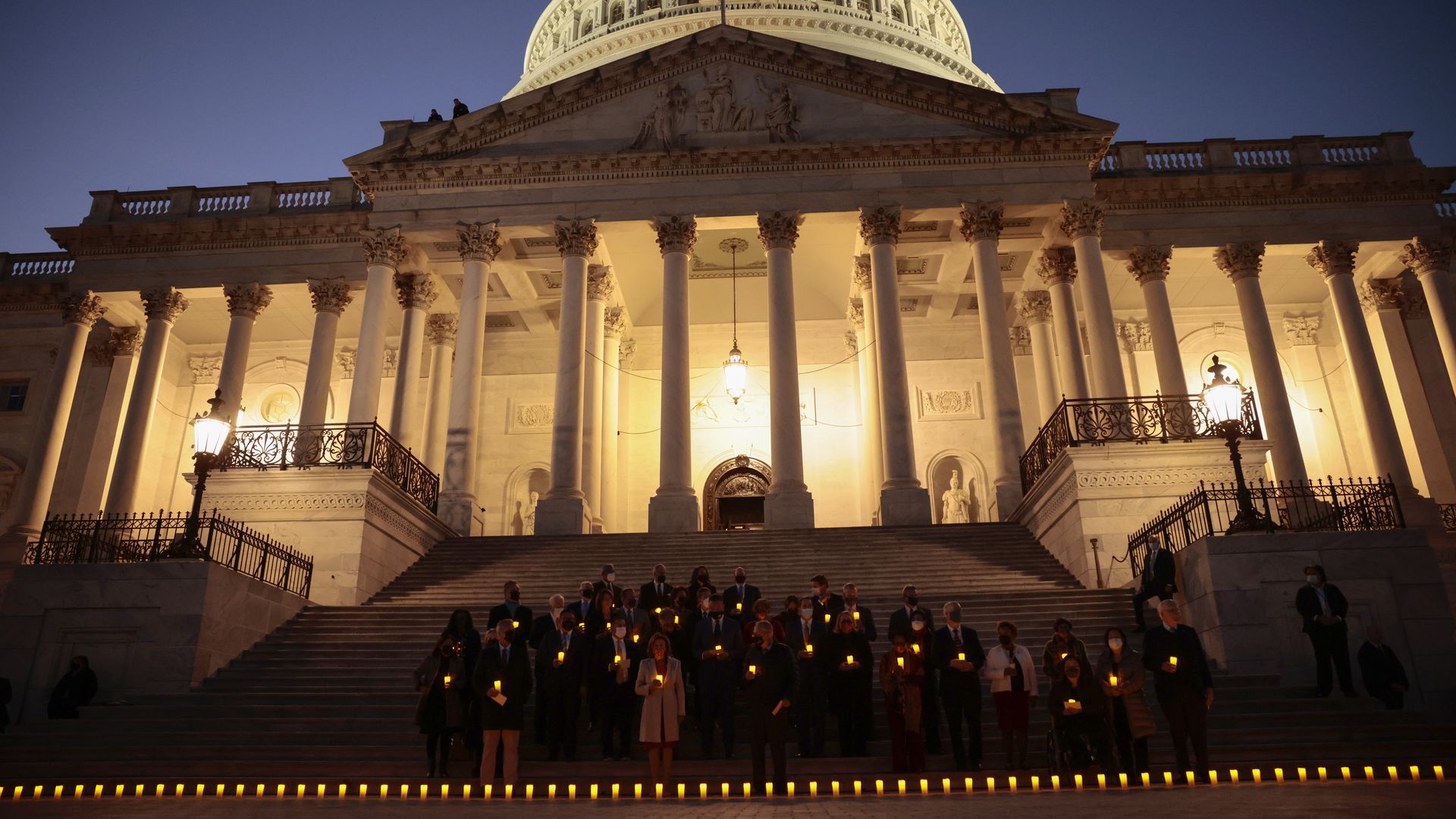 Lawmakers are seen in front of the Capitol during a candlelight vigil to recall the nation's COVID-19 victims.