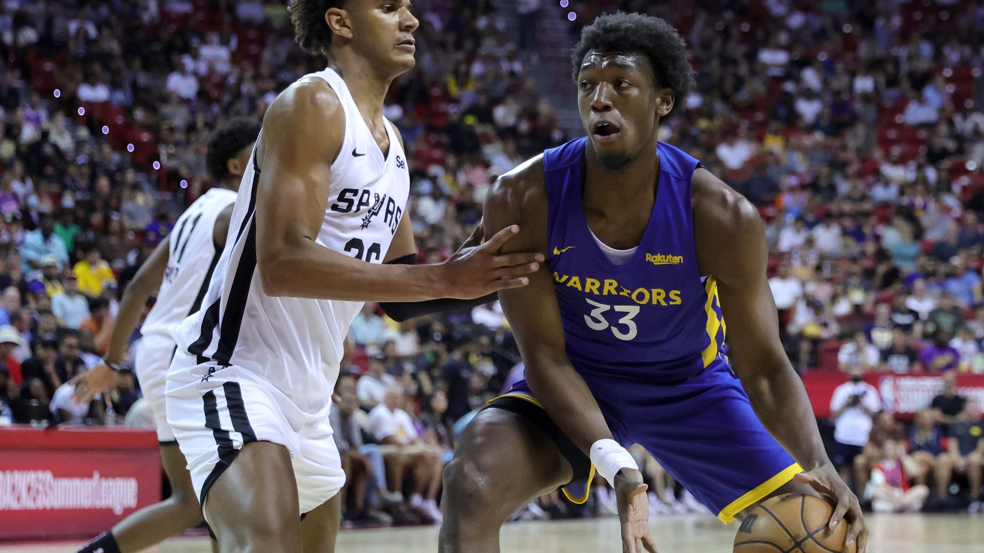 James Wiseman dribbles the ball wearing a blue Warriors jersey.