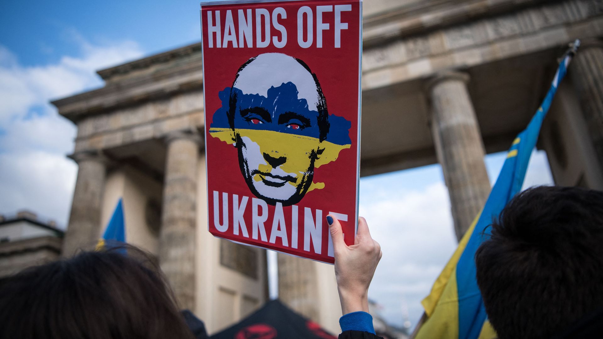  A protester holds up a poster reading "Hands Off Ukraine" and depicting the face of Russian President Vladimir Putin during a demonstration in Berlin on Feb. 19.