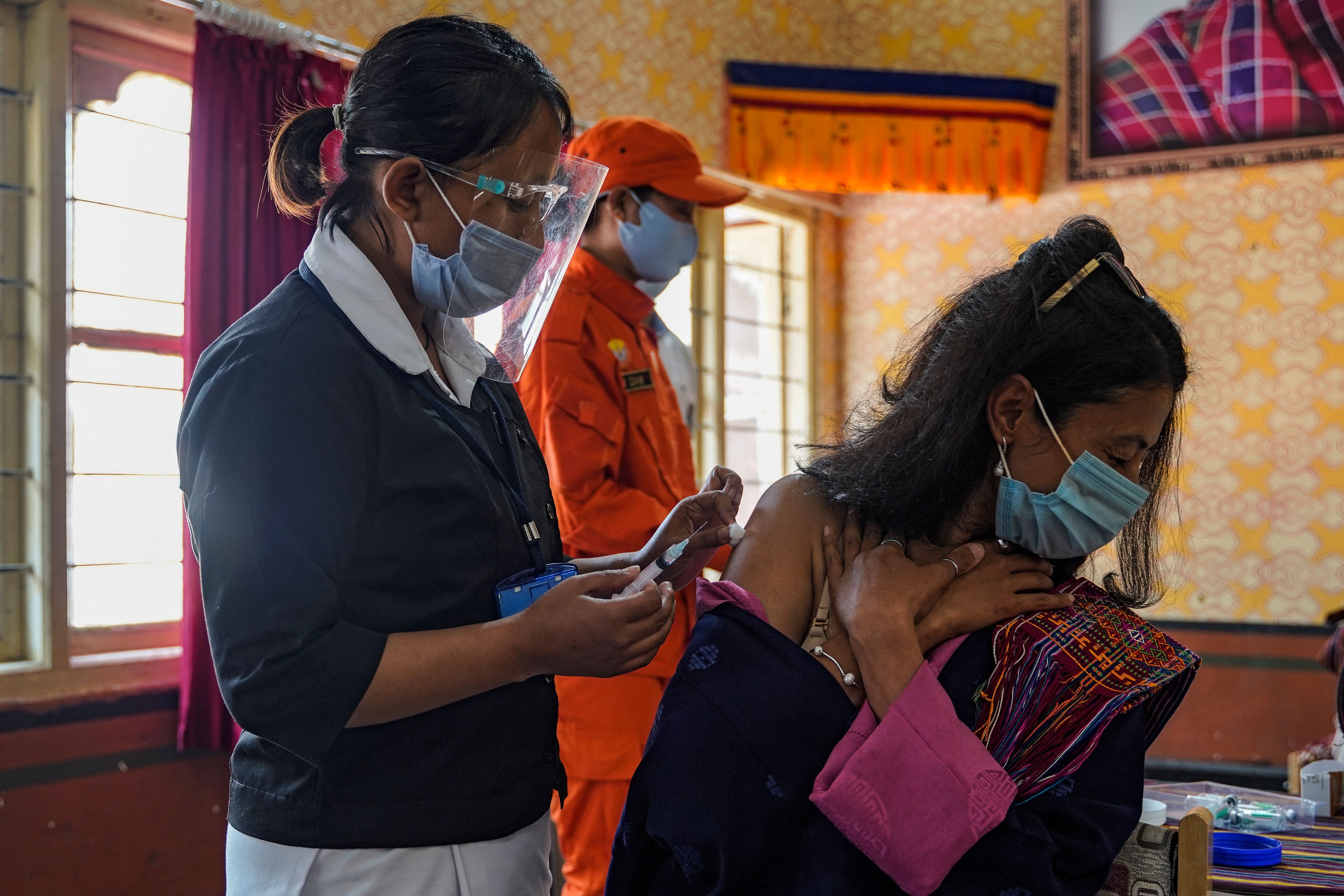 A health worker inoculate a dose of a COVID-19 coronavirus vaccine to a woman during the first day of vaccination in Bhutan, at Lungtenzampa Middle Secondary school in Thimphu on March 27