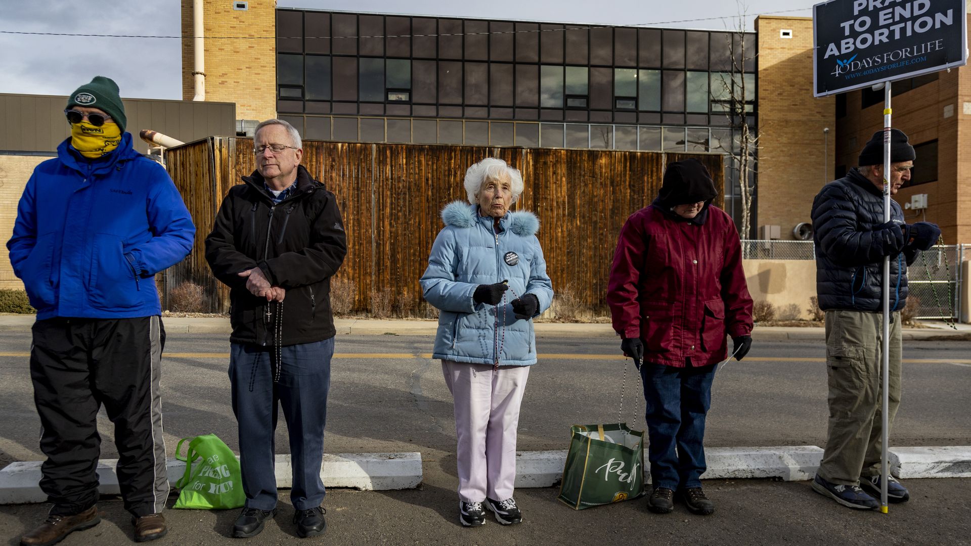 Anti-abortion protesters pray and hold signs in front of the Boulder Abortion Clinic.