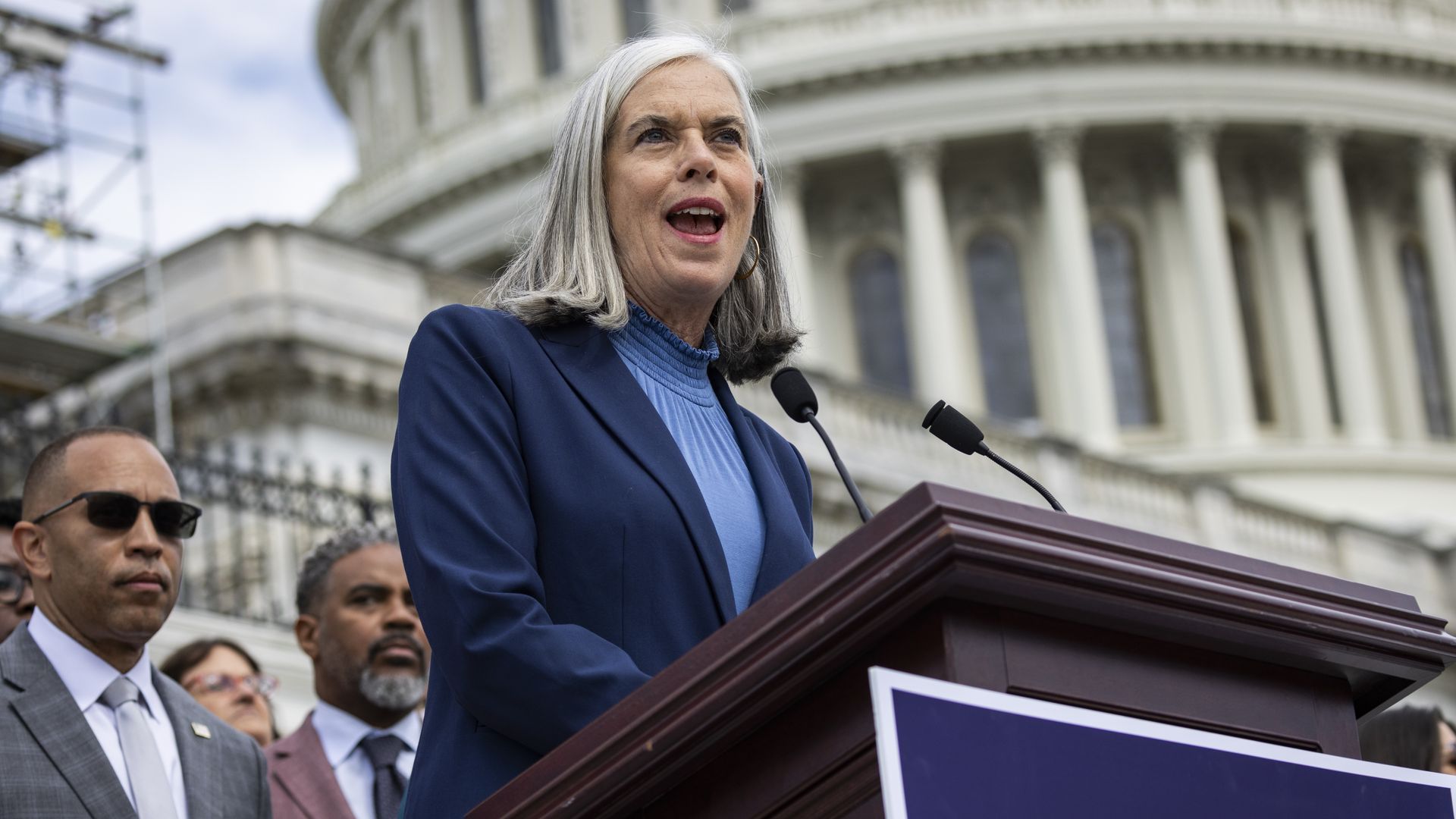 House Minority Whip Katherine Clark, wearing a blue suit and standing in front of the Capitol.