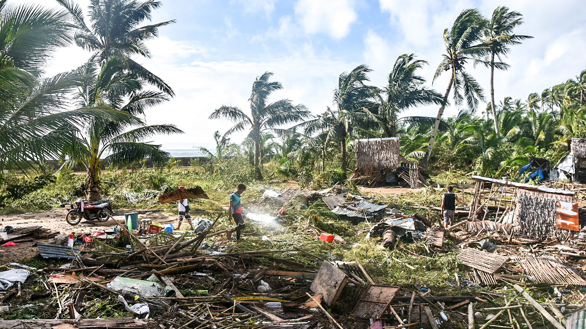 Residents walk past their destroyed homes in Hernani town, Eastern Samar province on December 17