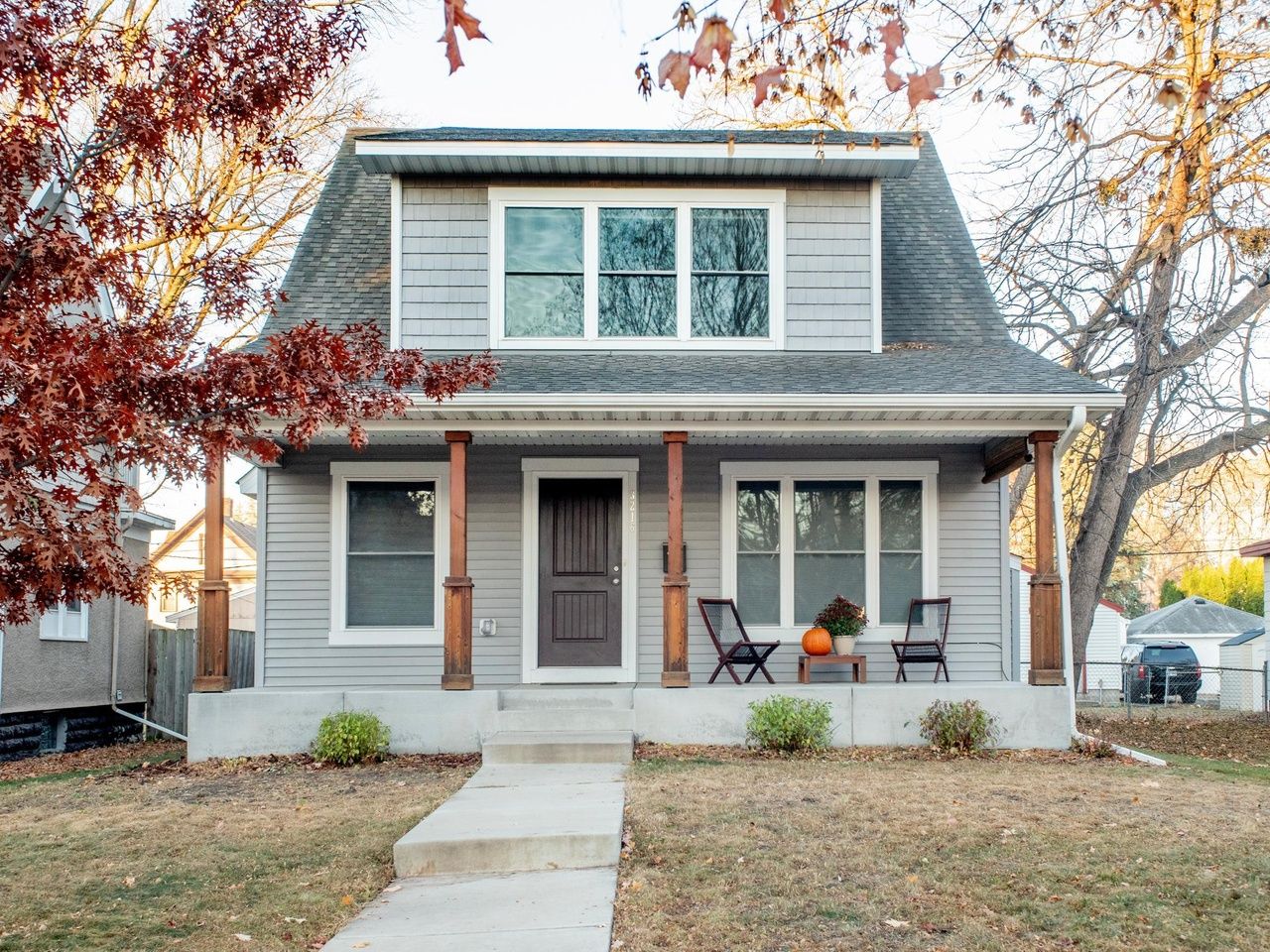 exterior of grey home with front porch and wood columns