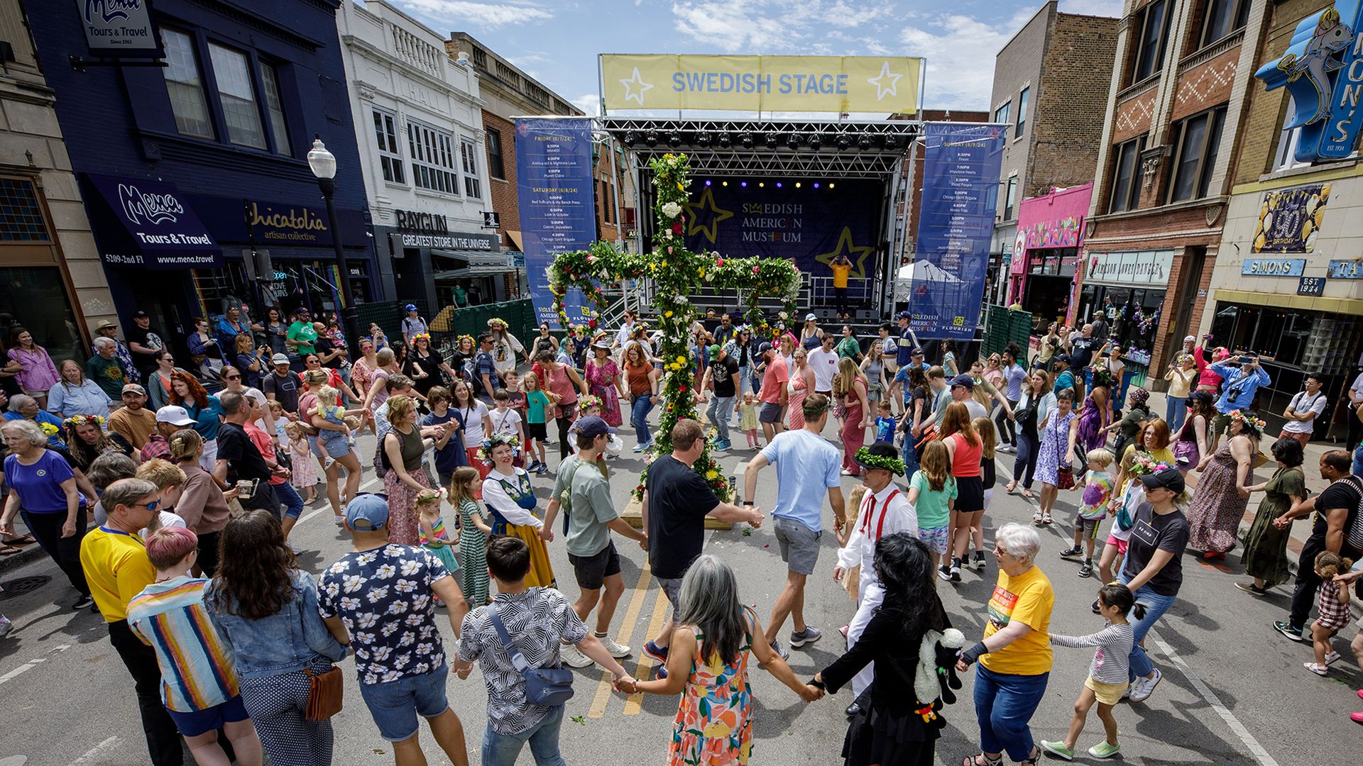 Street festival with people holding hands.