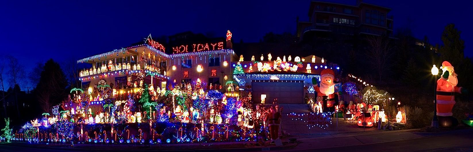 A house stands on a mountain with scores of holiday decorations and lights.