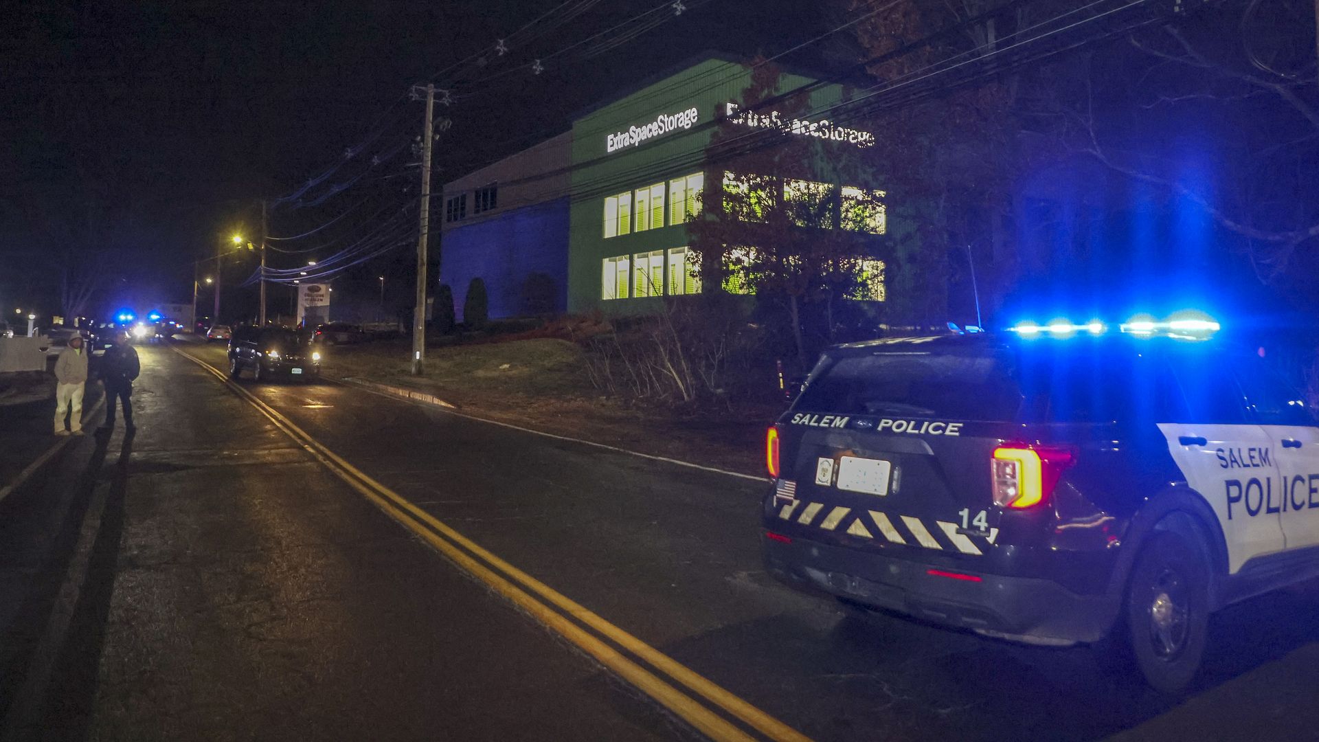 A police car and officers on scene in the dark at the Extra Space Storage facility where the Brown University shooting suspect was found dead on Dec. 18.