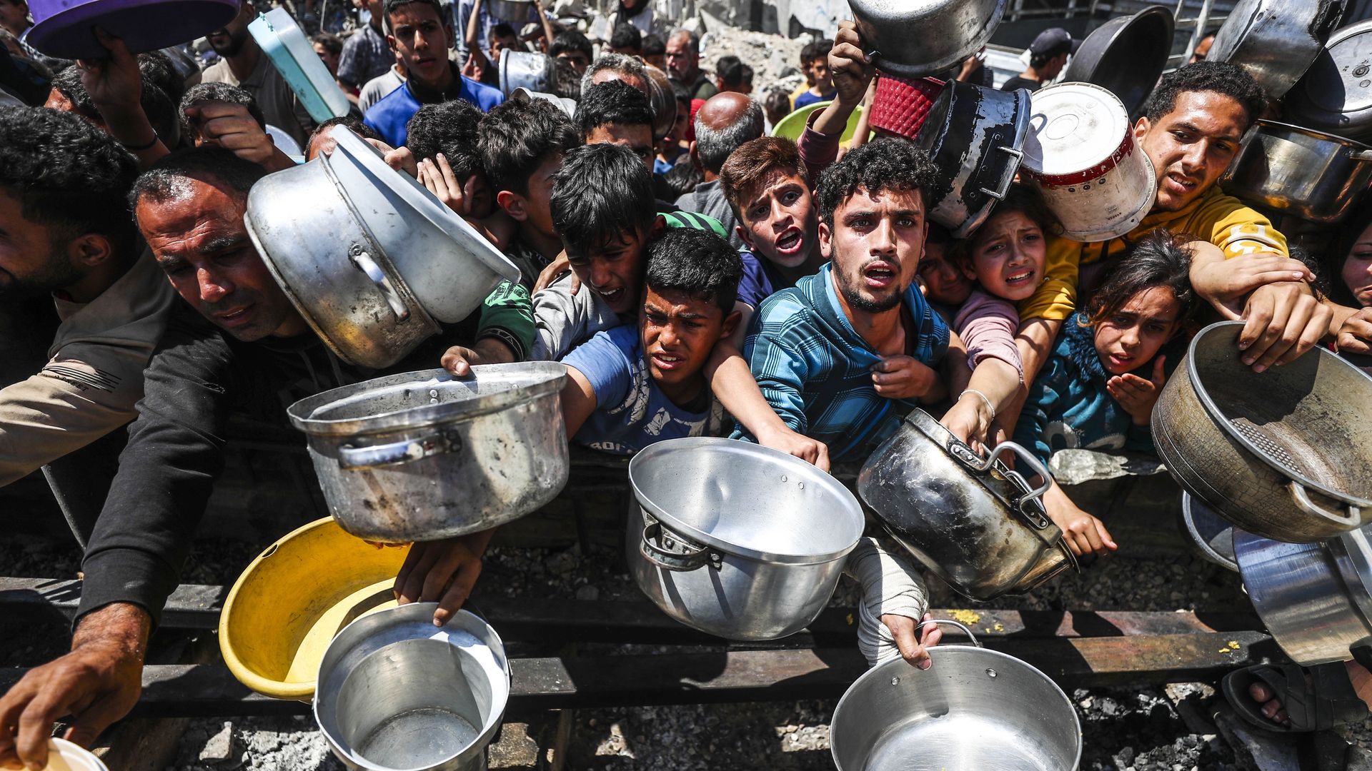 Displaced Palestinians receive hot meals distributed by aid organizations in Jabalia refugee camp of Jabalia, Gaza on May 05, 2025