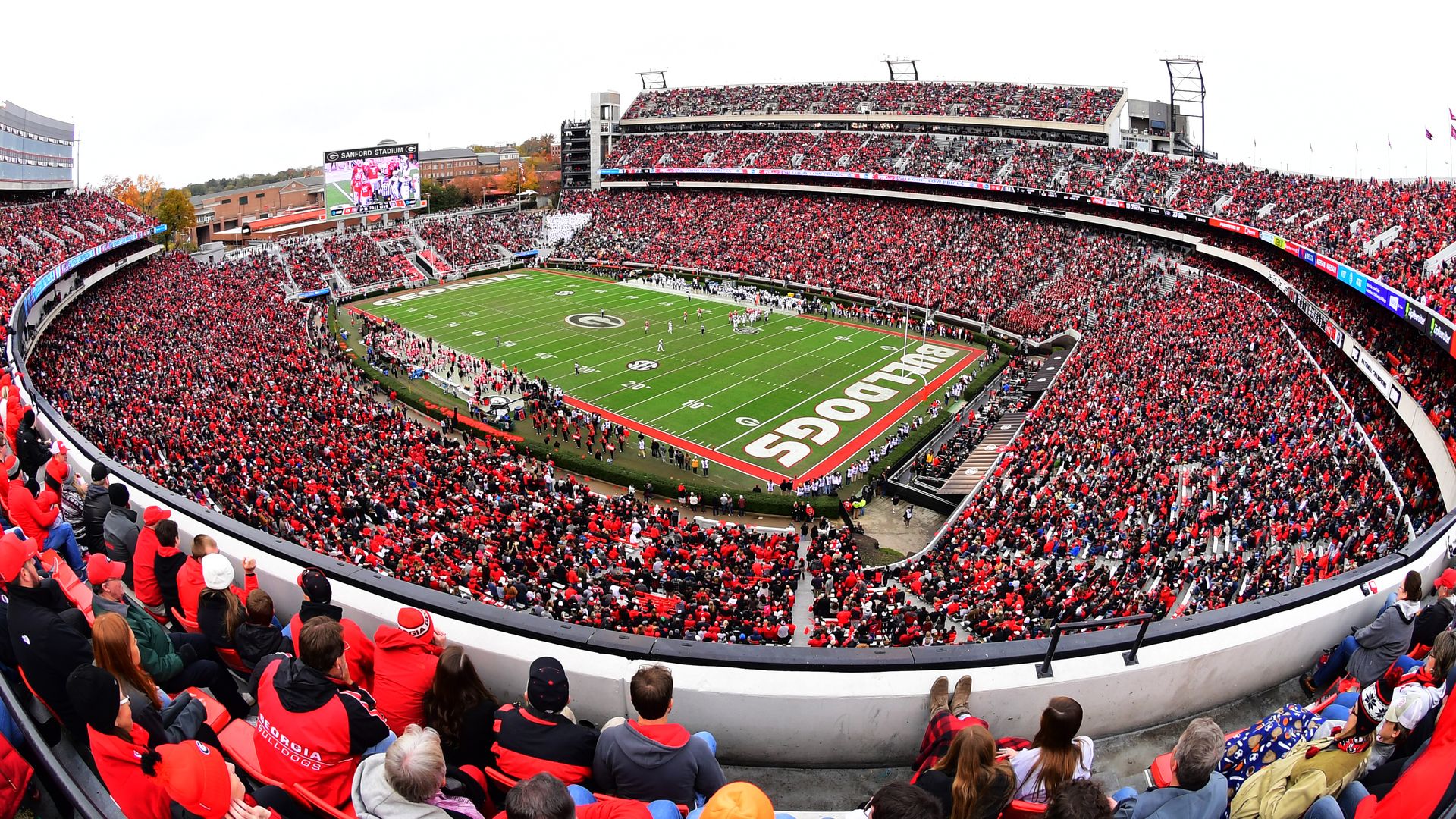 A wide-angle photo of UGA's Sanford Stadium packed with Bulldogs fans wearing red and black on gameday