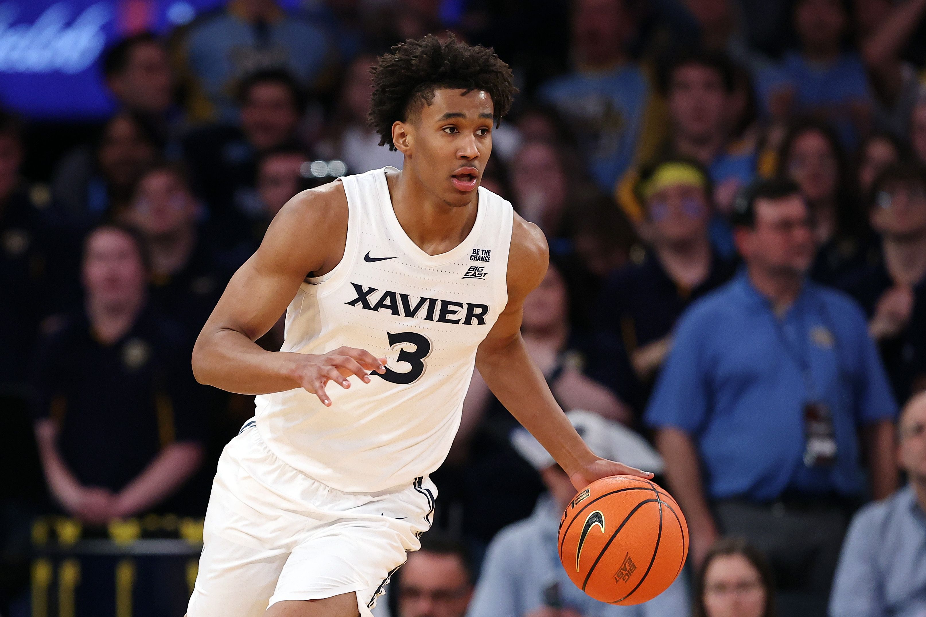 Photo of a man in a basketball uniform dribbling a basketball. 