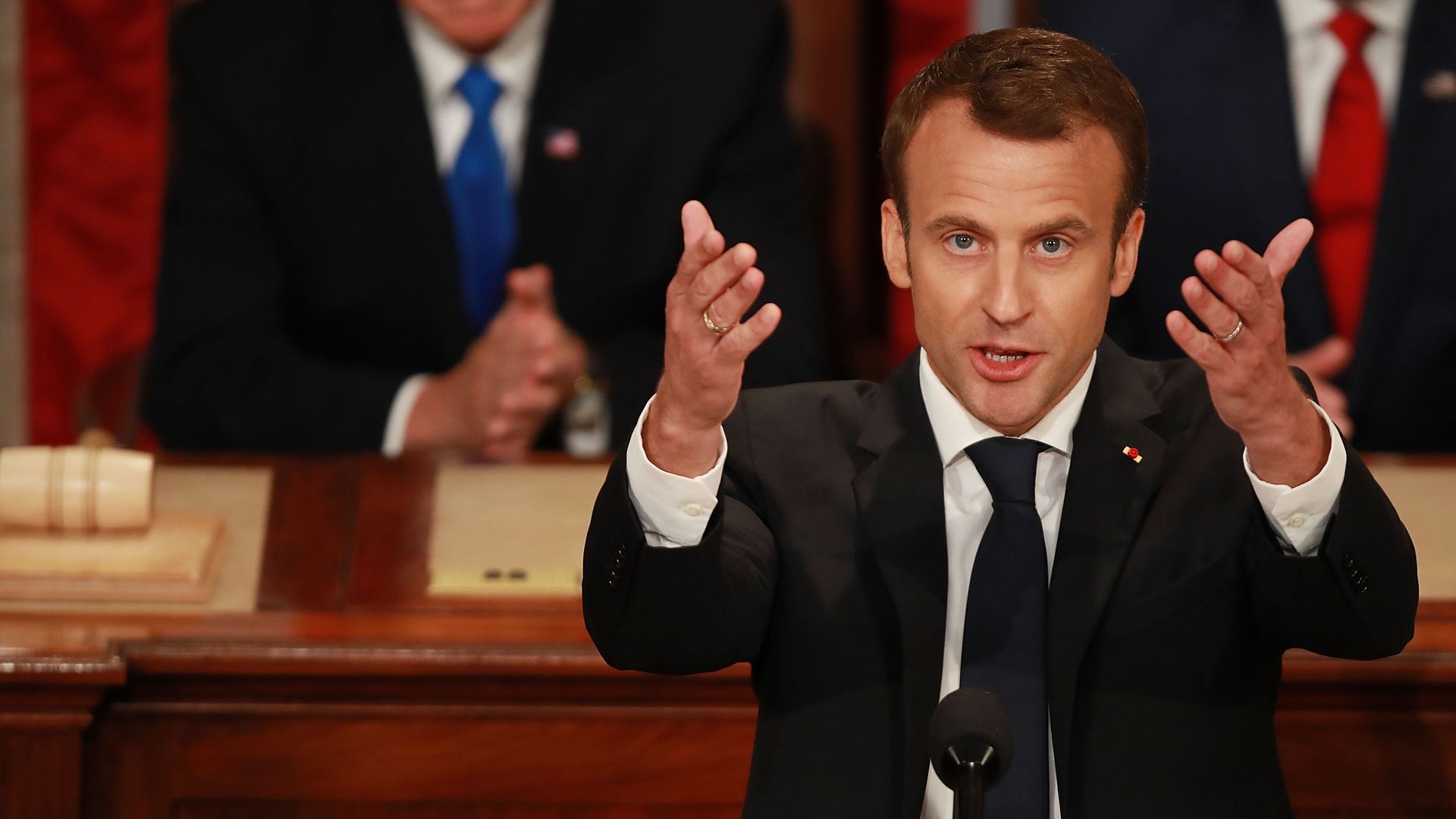 Emmanuel Macron holds both palms upwards.