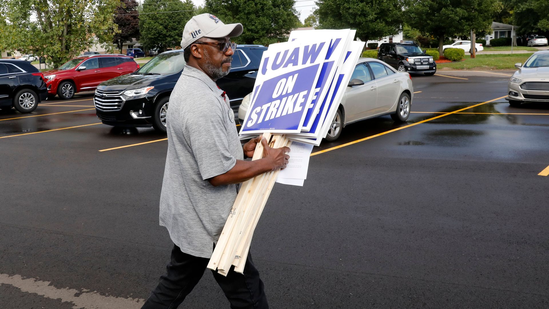 General Motors Co. employee Carl More carries strike signs to his car at the United Auto Workers (UAW) Local 163 which represents GMs Romulus Powertrain on September 15, 2019 in Westland, Michigan