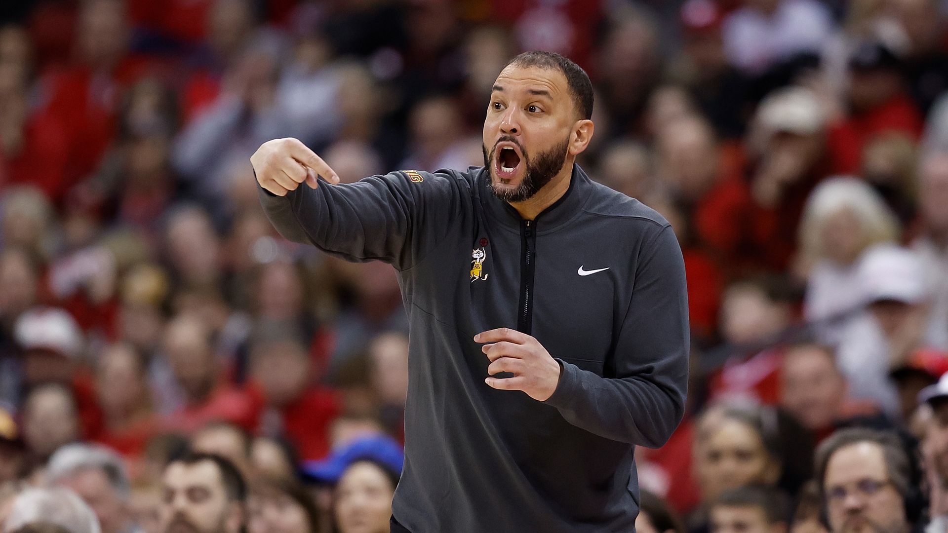 A photo of Ben Johnson making hand signals to his players 