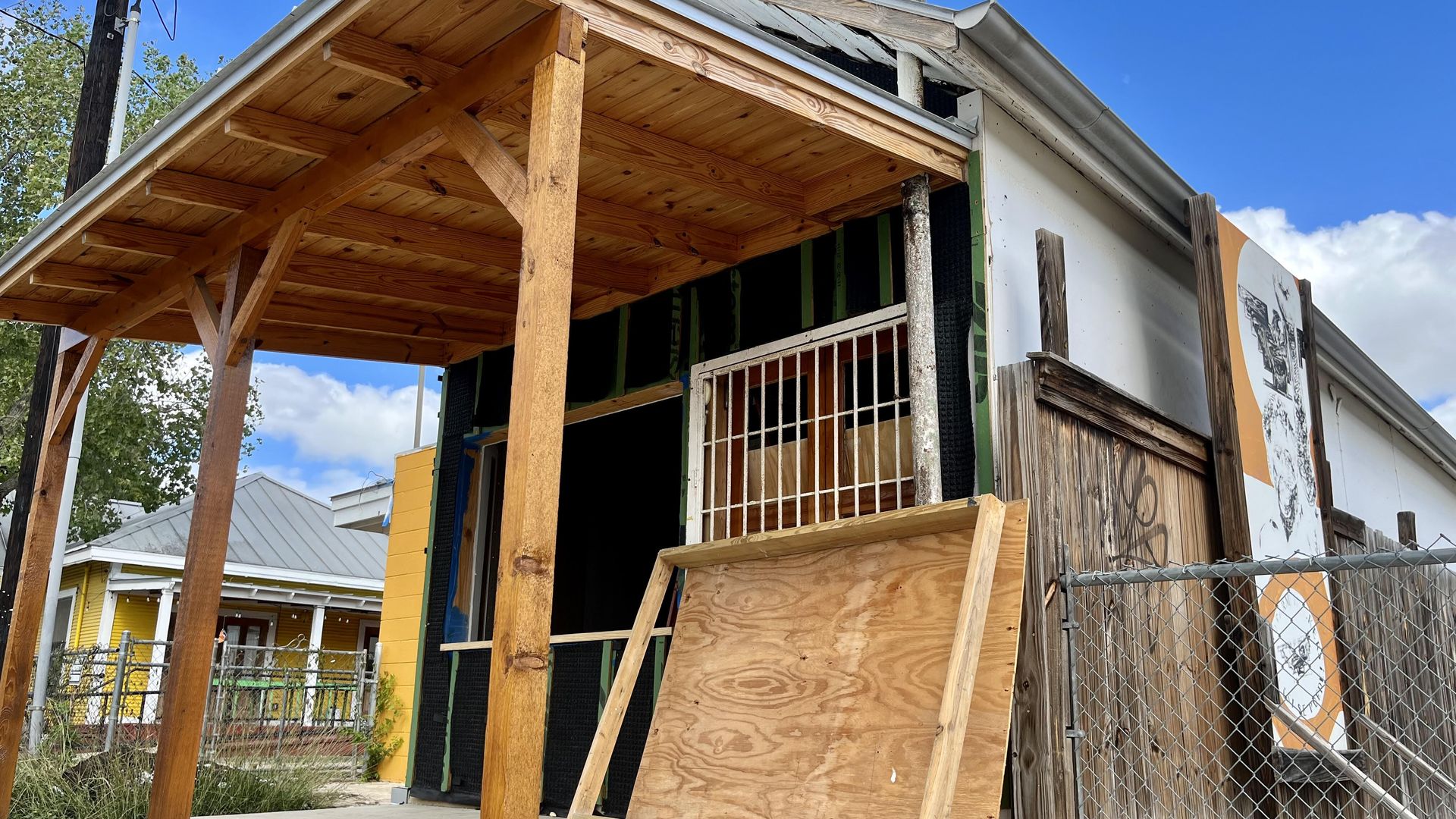 A small building with a wooden patio under construction. 