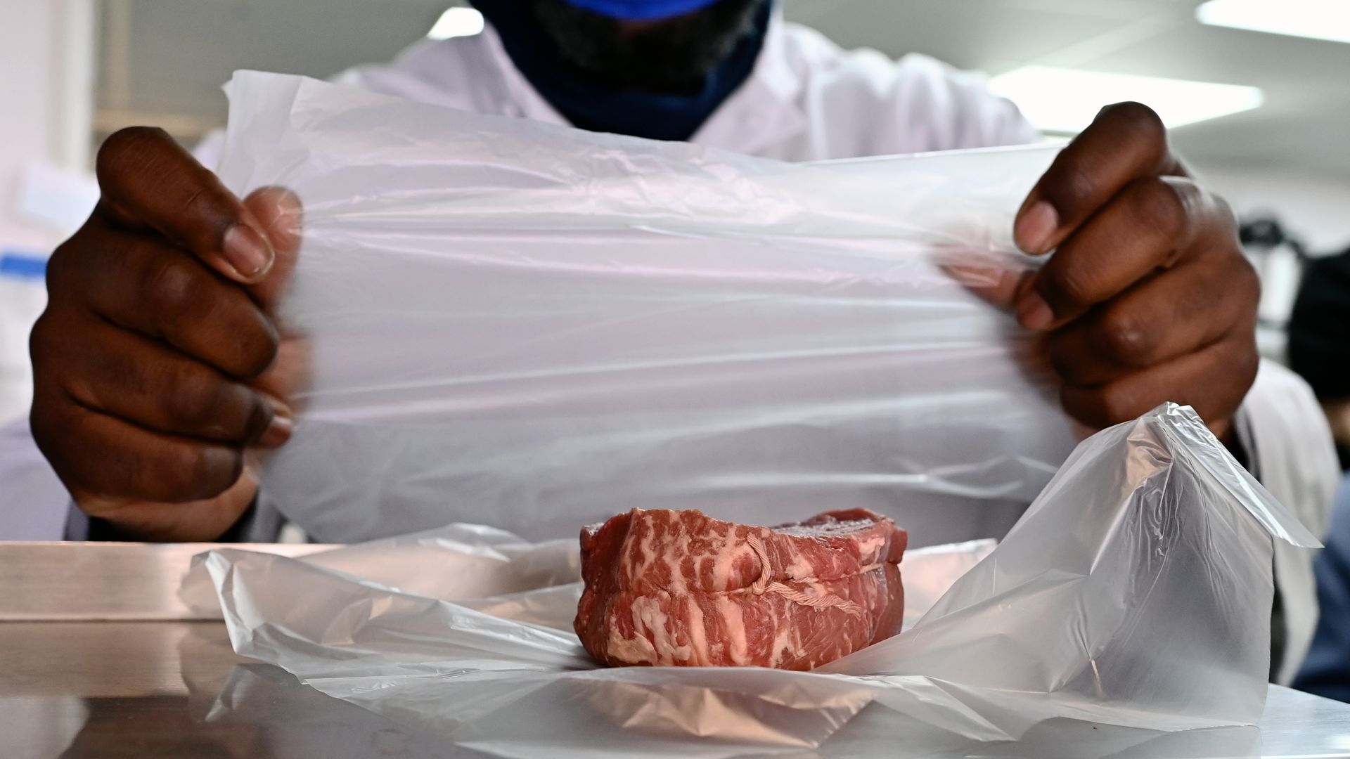 A butcher wraps up a steak