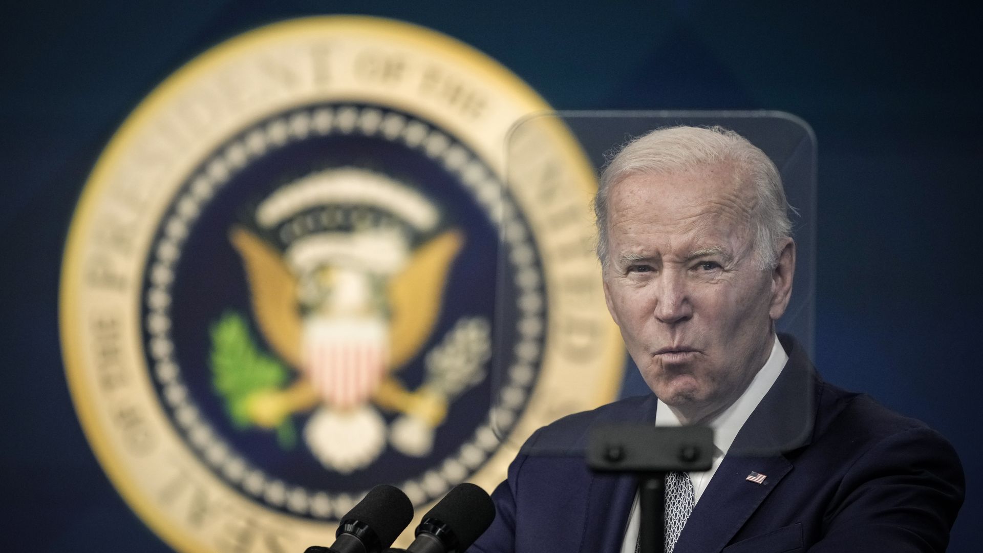 President Biden is seen through the pane of a TelePrompTer as he speaks about inflation on Tuesday.