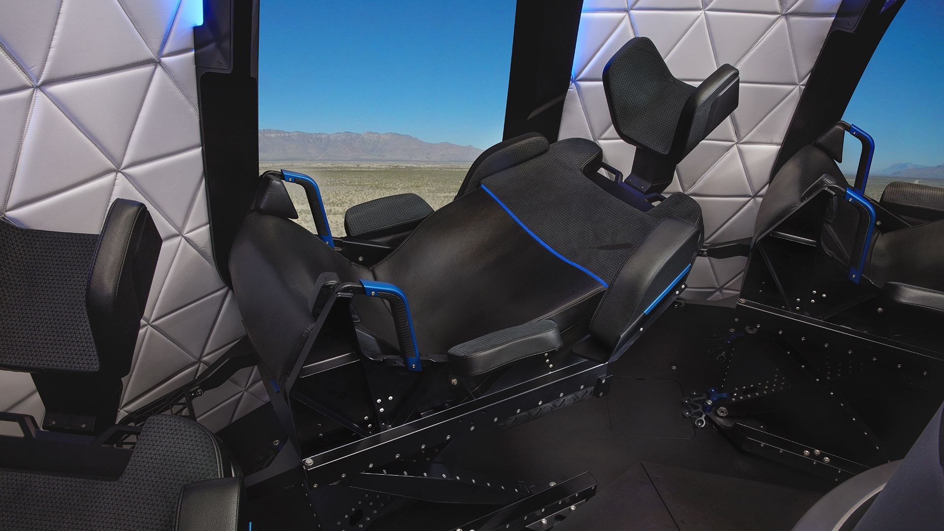 A seat inside of a capsule with a view of mountains out the window