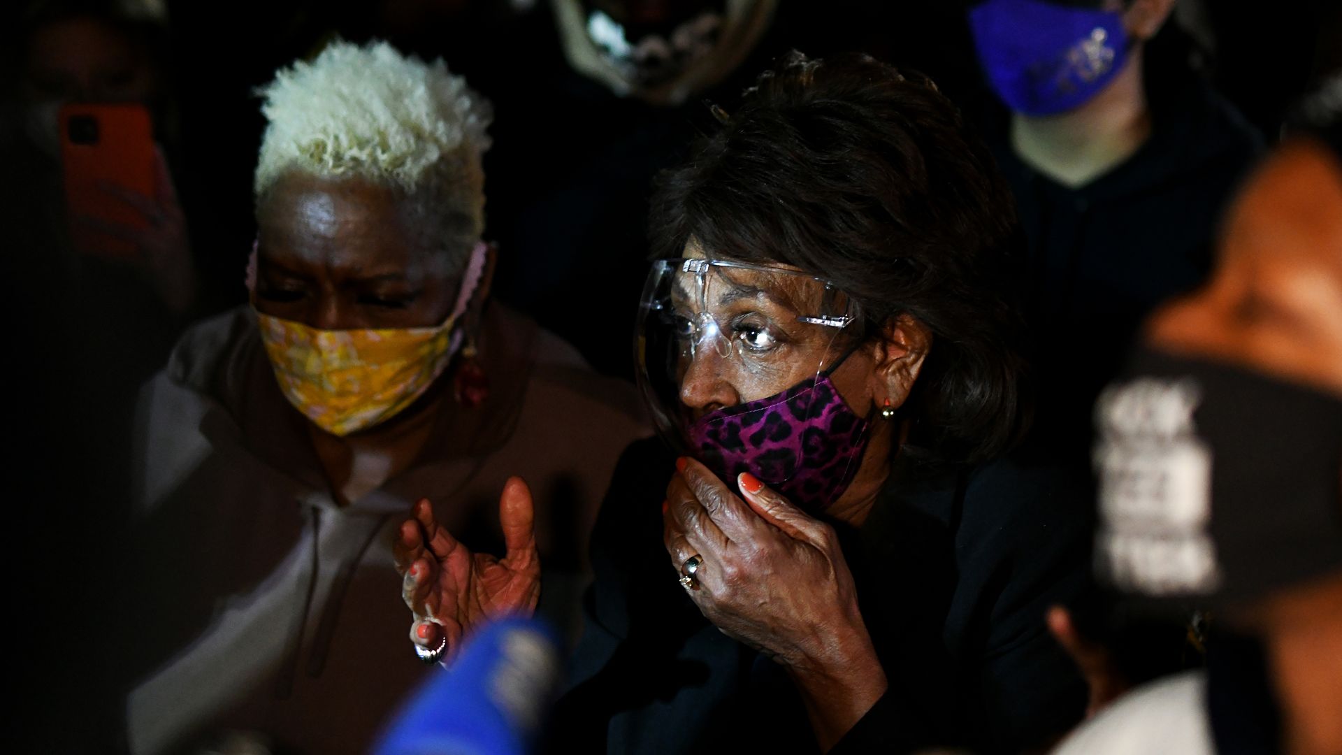 Photo of Maxine Waters surrounded by protesters