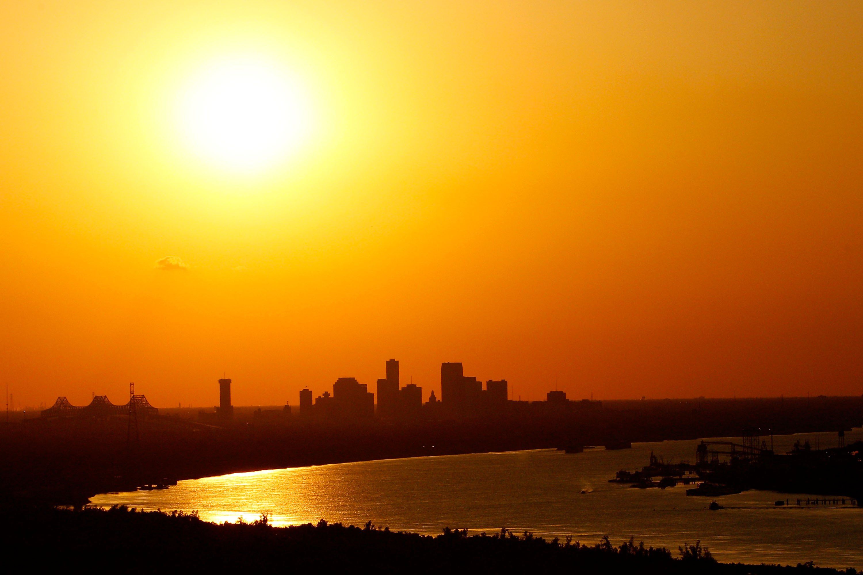 Image shows a skyline of New Orleans with a bright yellow sun.