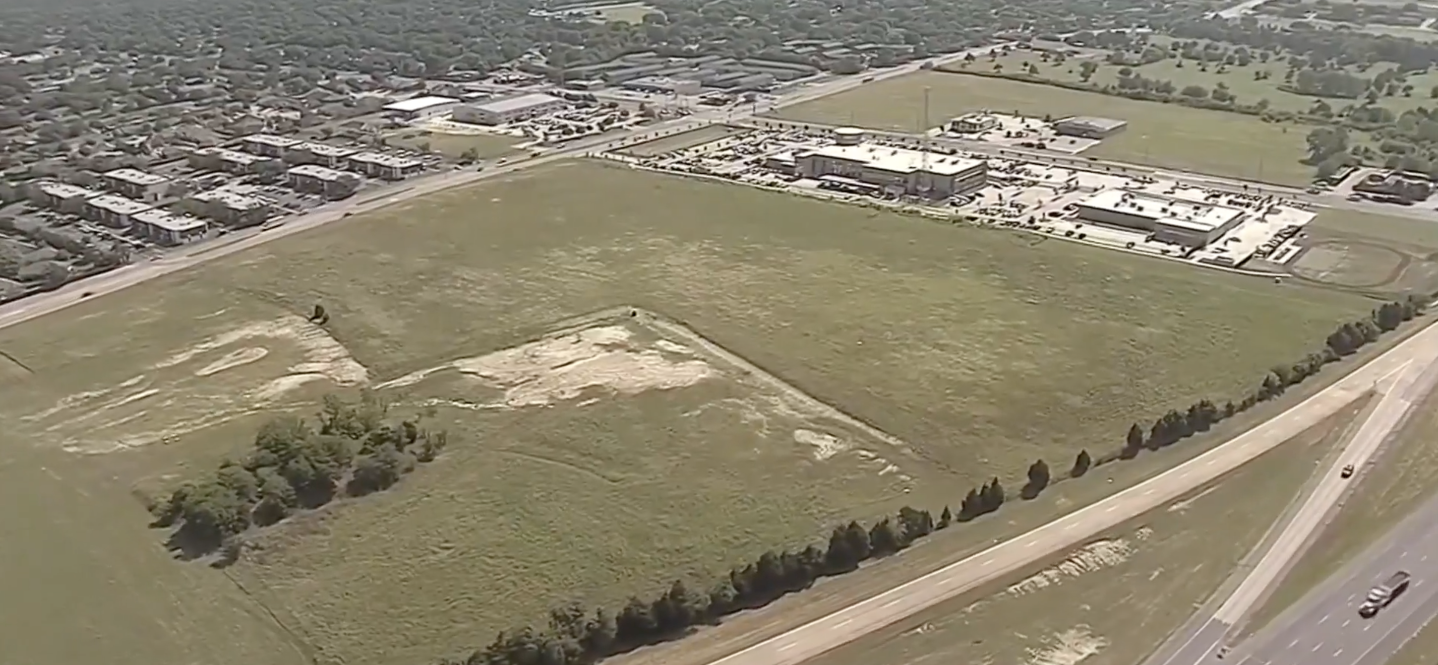 An open field lined with trees