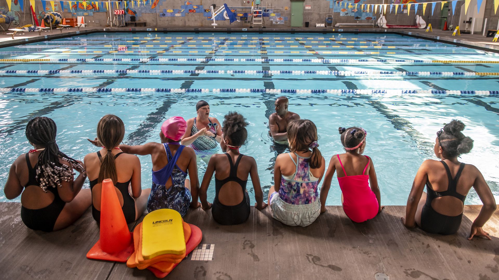 kids sitting at a swimming pool