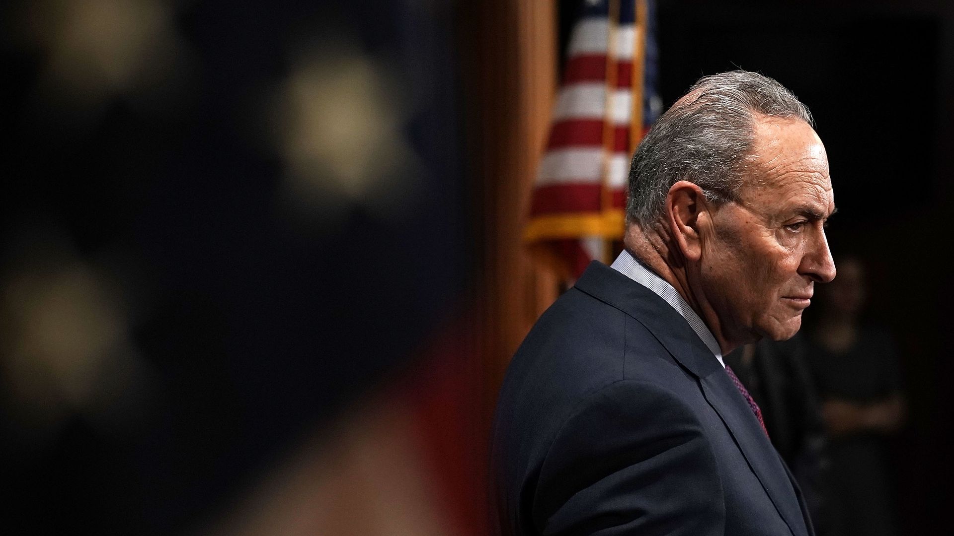 Senate Minority Leader Chuck Schumer listens at a press conference