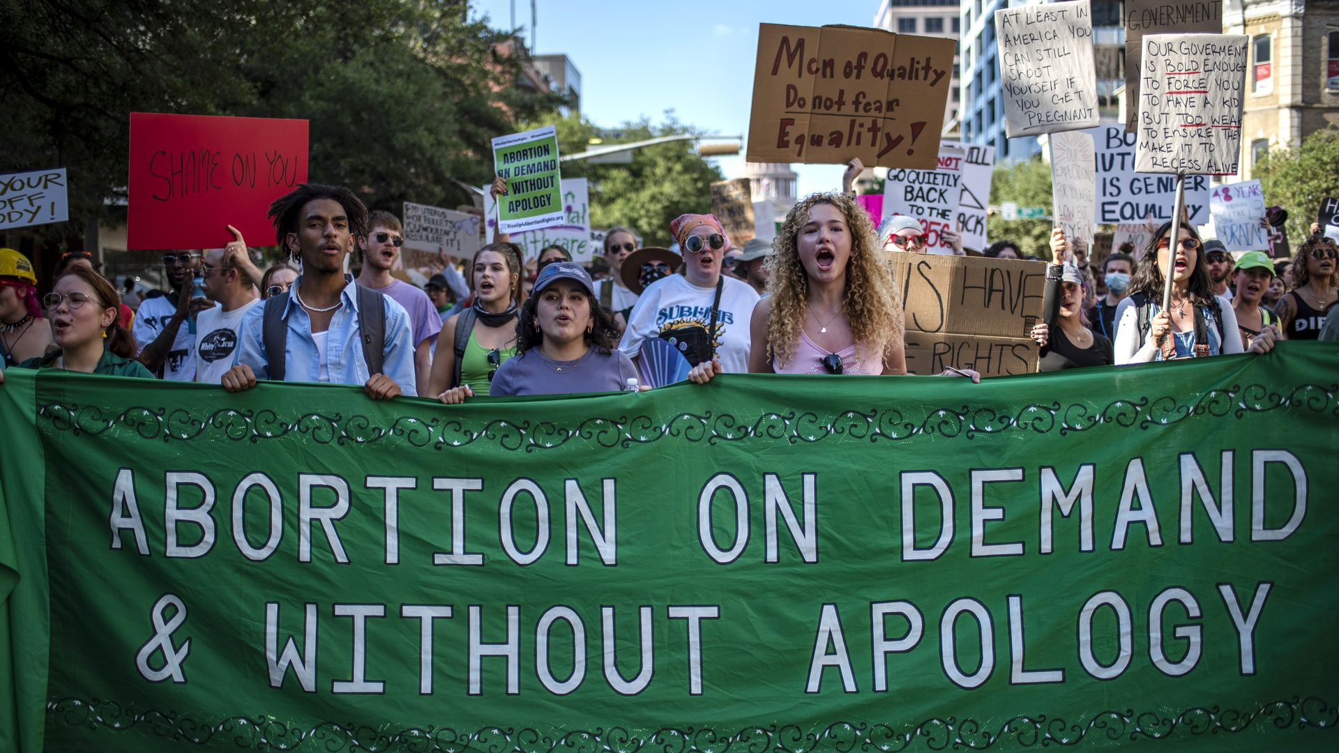 Protesters march while holding signs during an abortion-rights rally on June 25, 2022 in Austin, Texa
