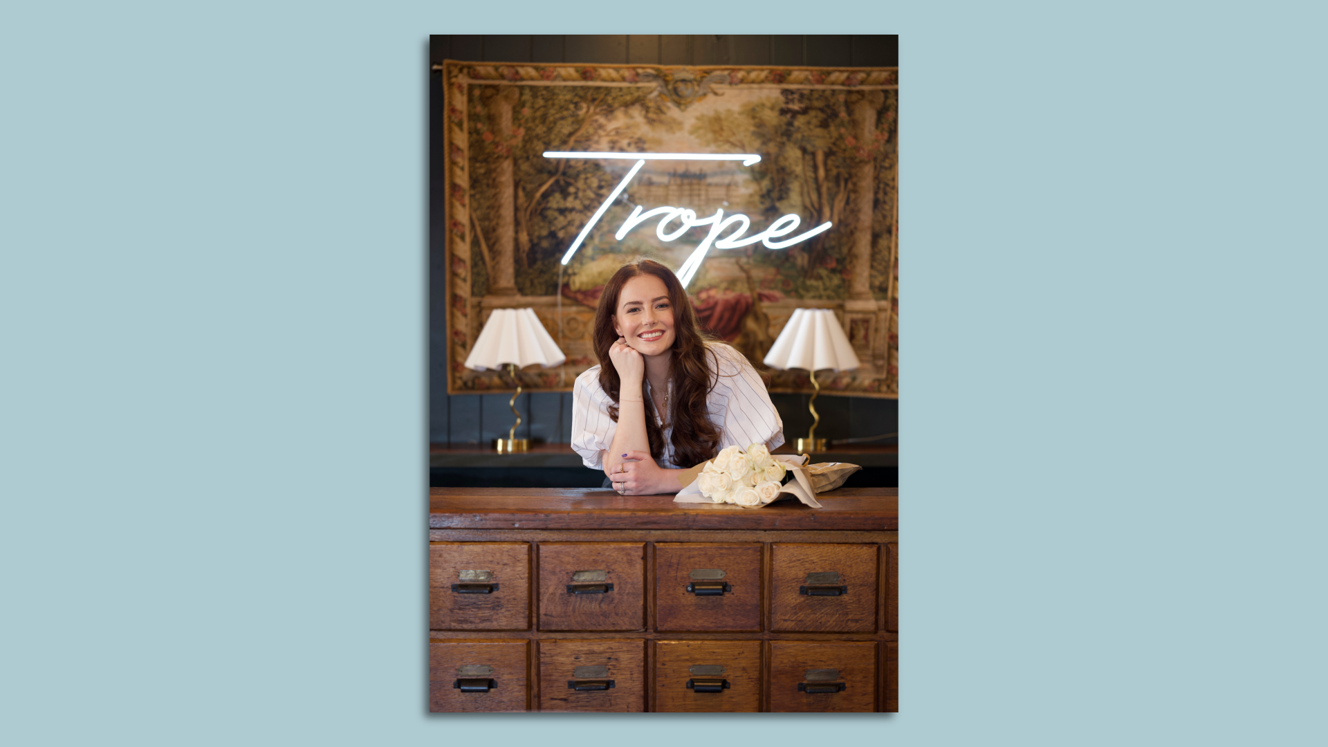 woman standing behind desk, smiling