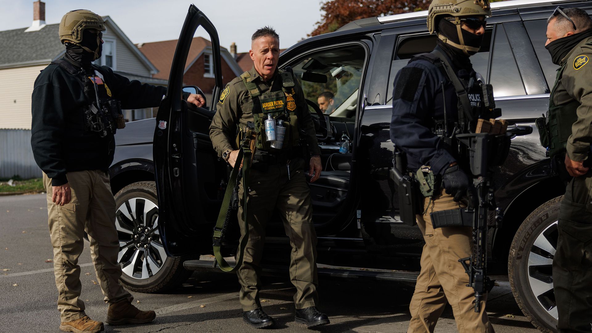 Photo shows Border Patrol Commander Gregory Bovino getting out of a black SUV with other agents.
