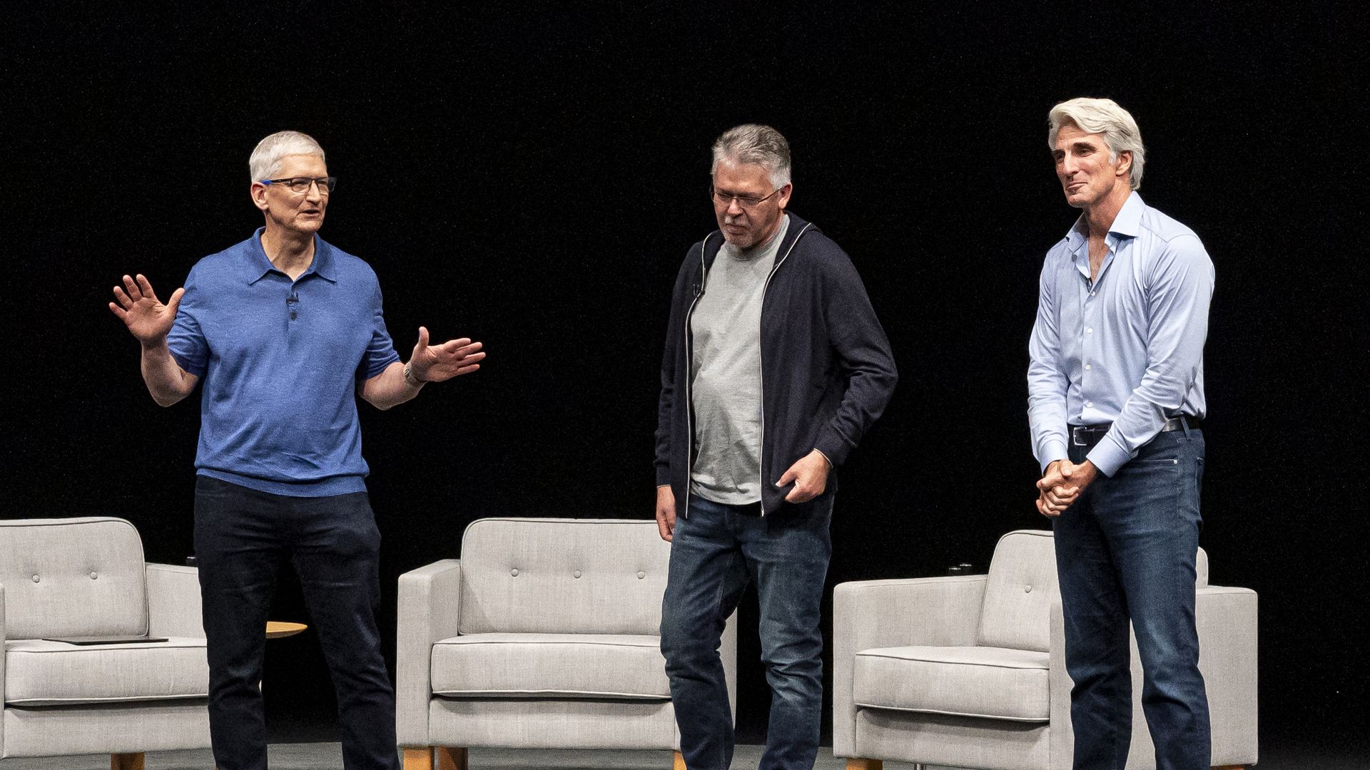 Three man in front of chairs on stage