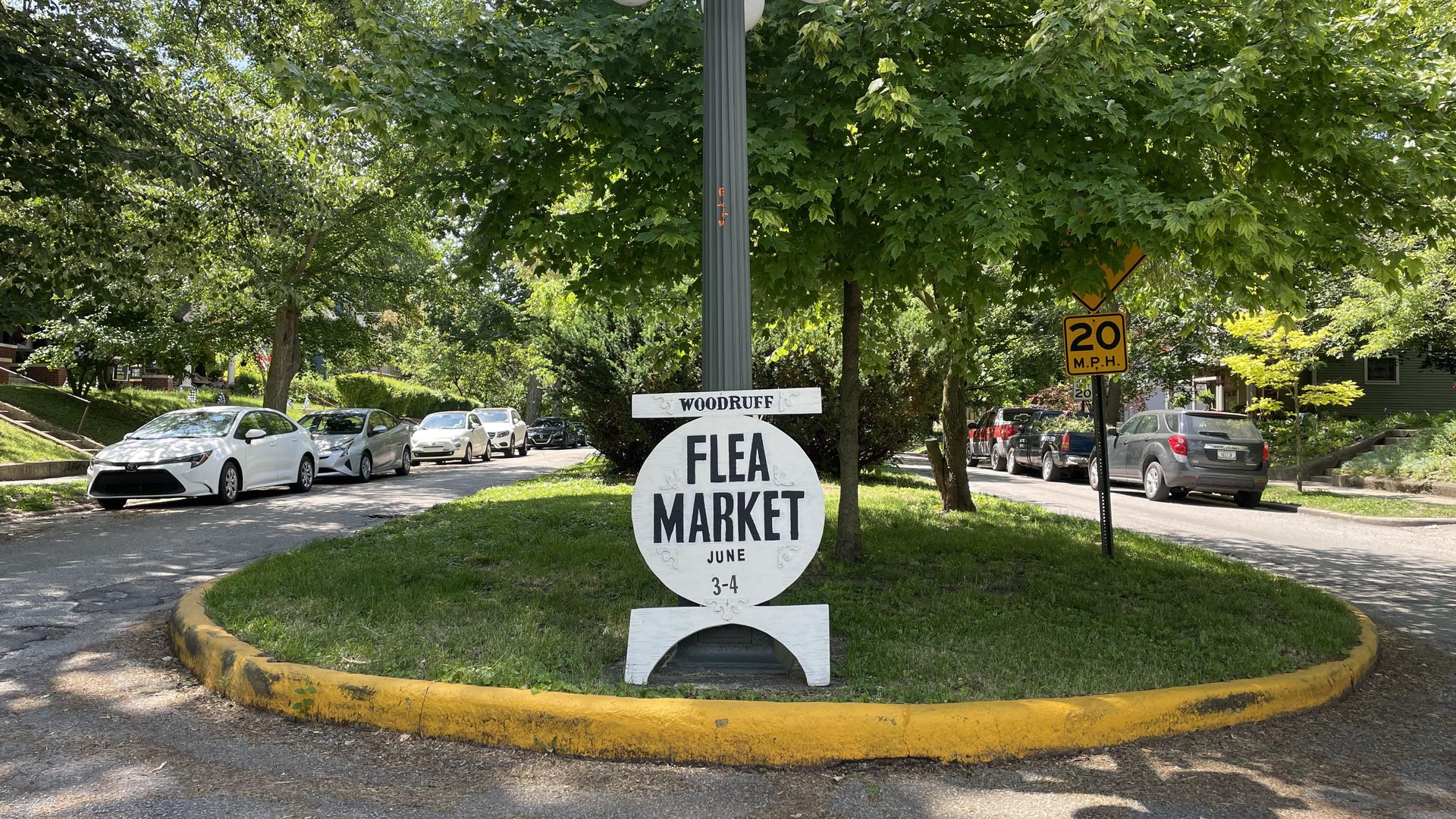 Sign that says "flea market" leaning against a lamp post on an esplanade