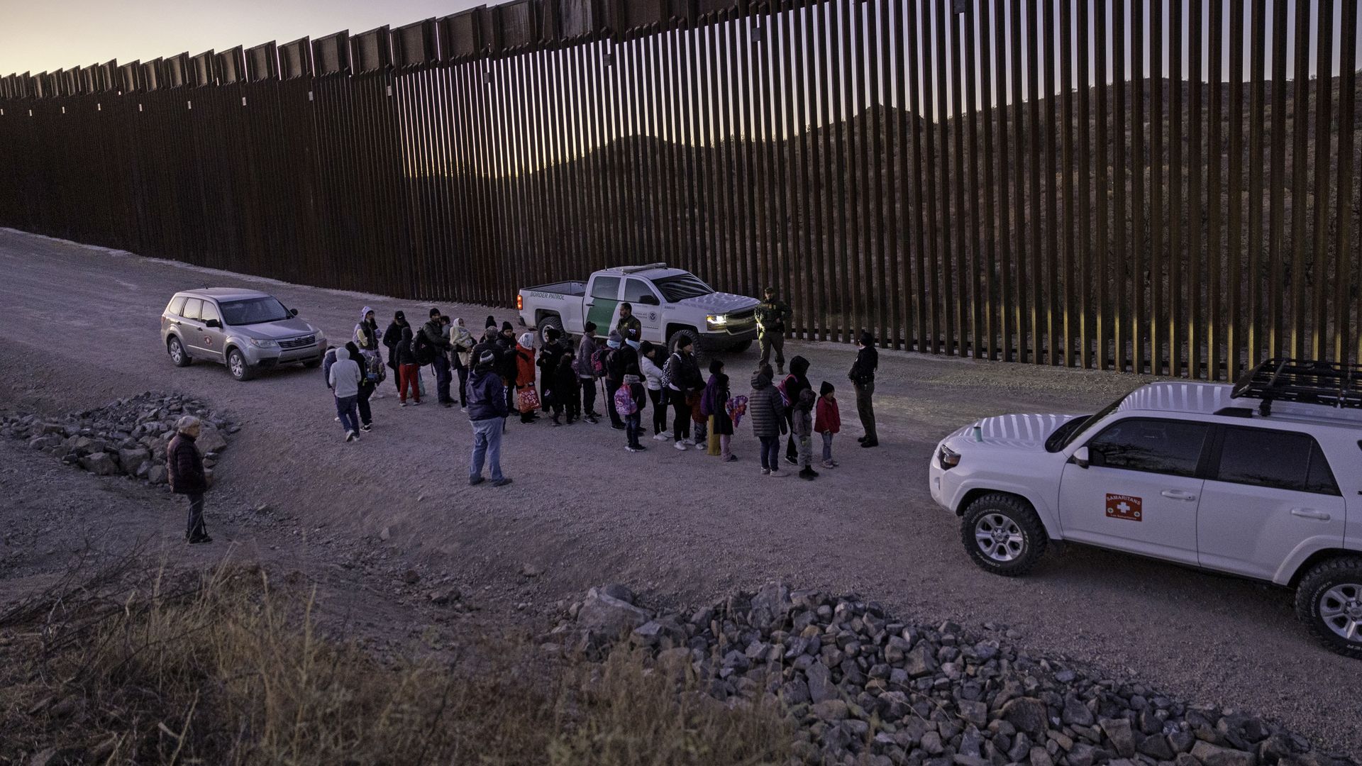 SASABE, ARIZONA - JANUARY 19: U.S. Border Patrol agents prepare to transport immigrants for processing next to the U.S.-Mexico border fence on January 19, 2025 near Sasabe, Arizona. Immigrant families and single adult males from numerous countries had passed through a gap in the Trump-built border f