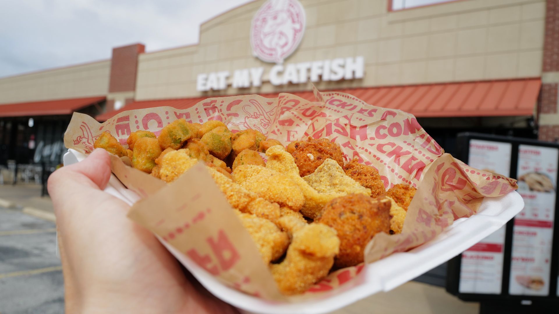 A takeout container of catfish, fried okra and hushpuppies from Eat My Catfish in Fayetteville.