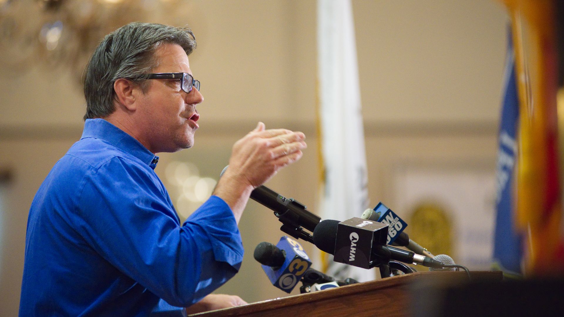 Philadelphia Councilman Bobby Henon speaks into microphones at a podium. 