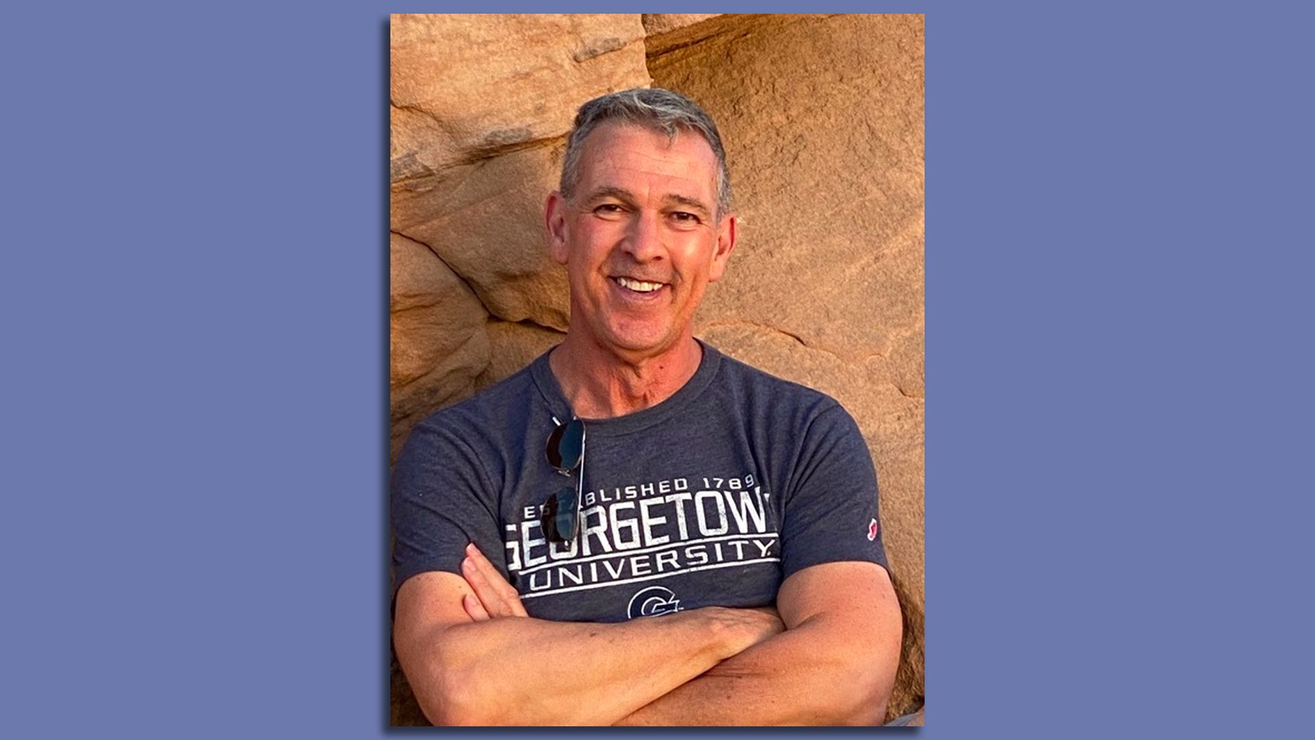 Ricardo L. Ortiz, English professor at Georgetown University, is seen posing for a photo while smiling and with his arms crossed. 