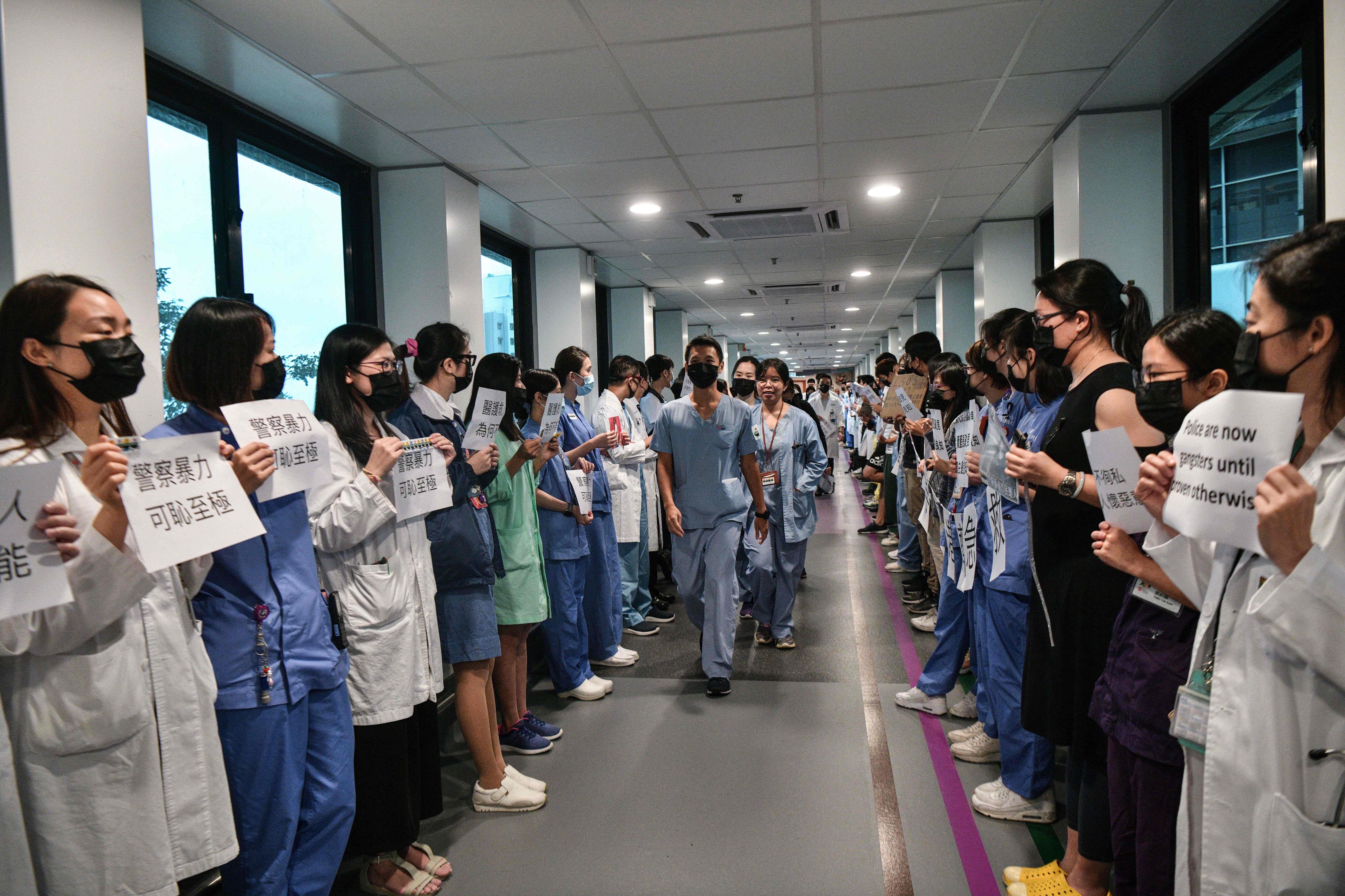  Medical staff hold posters as they form a human chain to express solidarity with anti-extradition bill protesters during their lunch break at the Queen Mary Hospital in Hong Kong on September 2