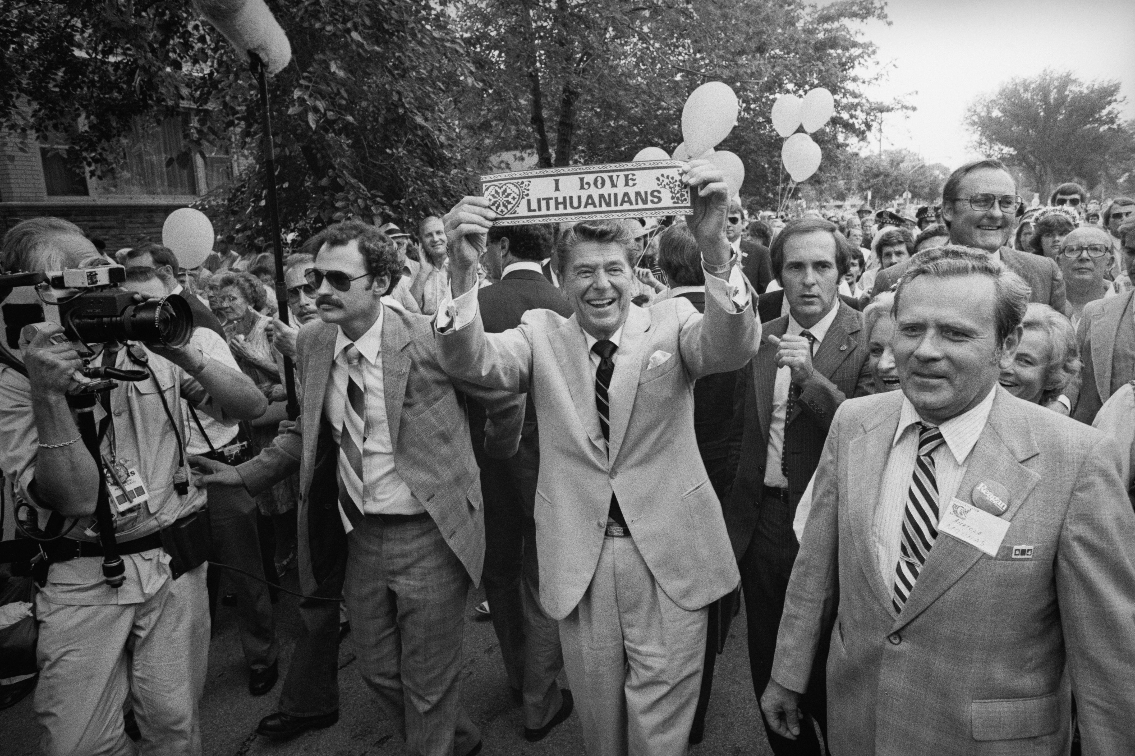 Photo of a man holding a sign during a parade.